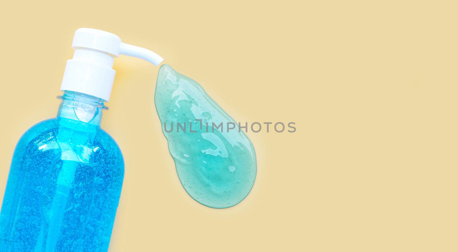 Alcohol hand sanitizer gel in pump bottles for hand hygiene corona virus (Covid-19) protection. yellow background with copy space.