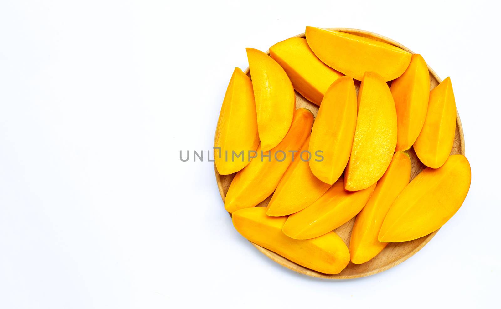 Tropical fruit, Mango  slices on wooden plate on white background. Copy space