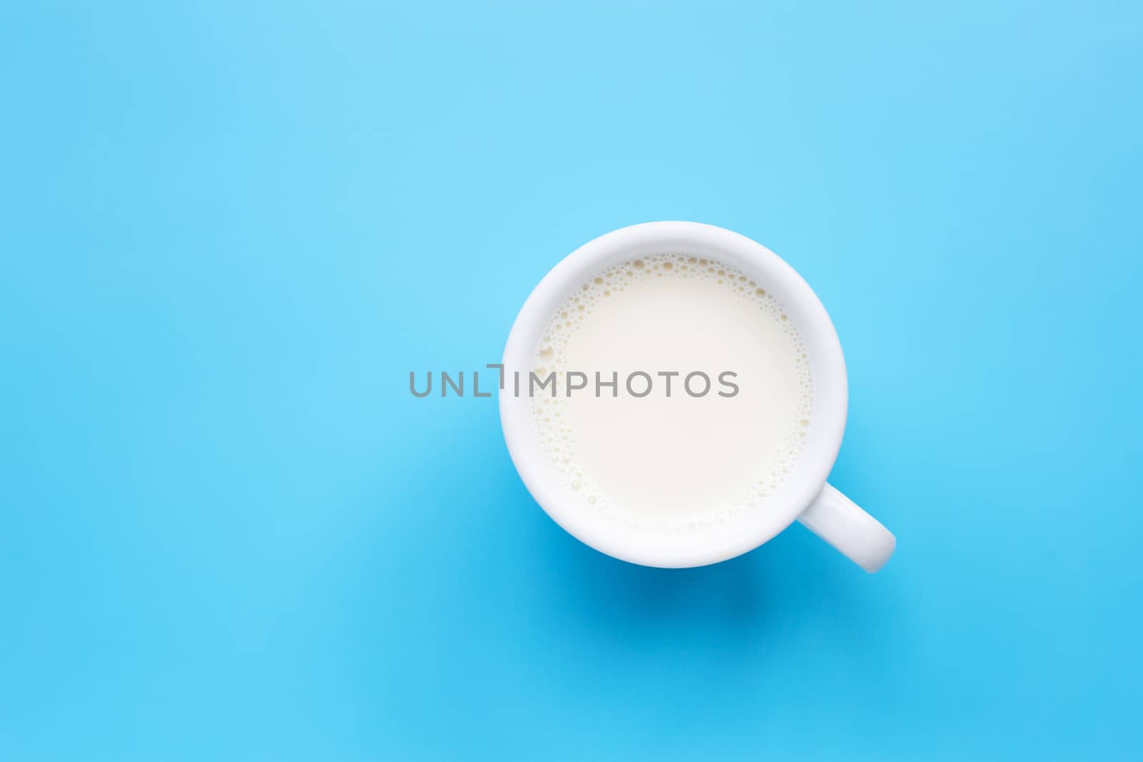 Cup of milk on blue background.  Copy space