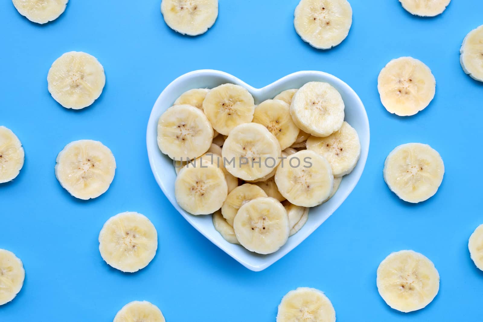 Banana slices on blue background. Top view