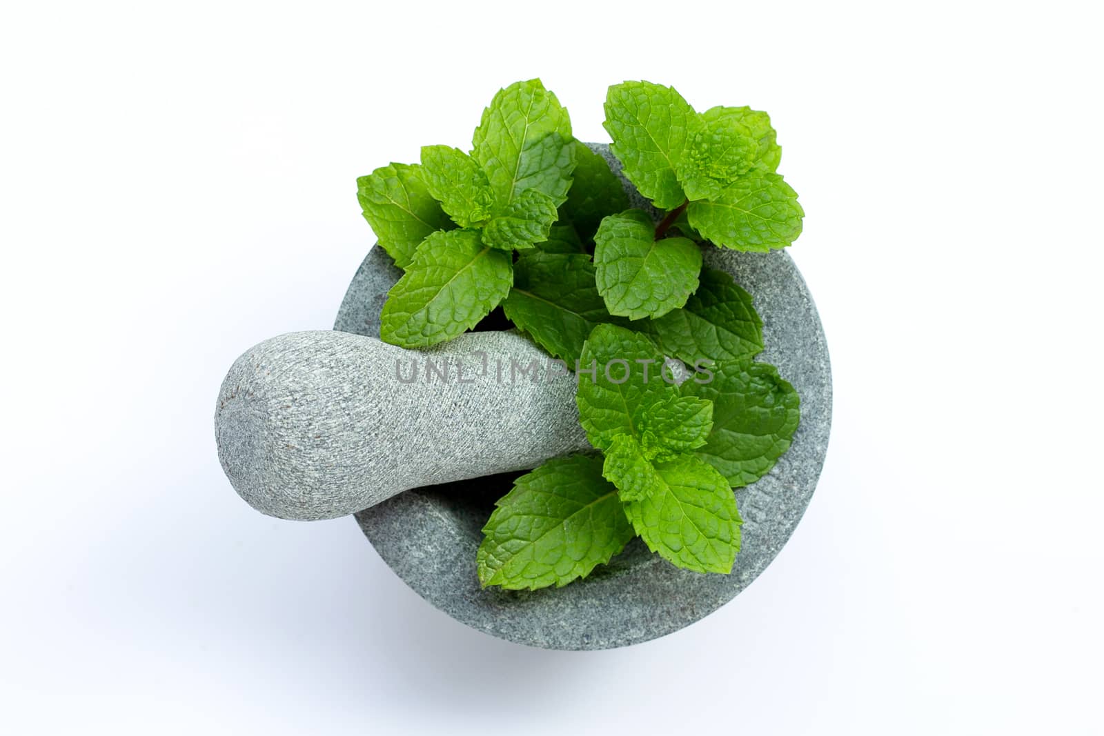 Mint leaves in stone mortar and pestle on white background. Top view