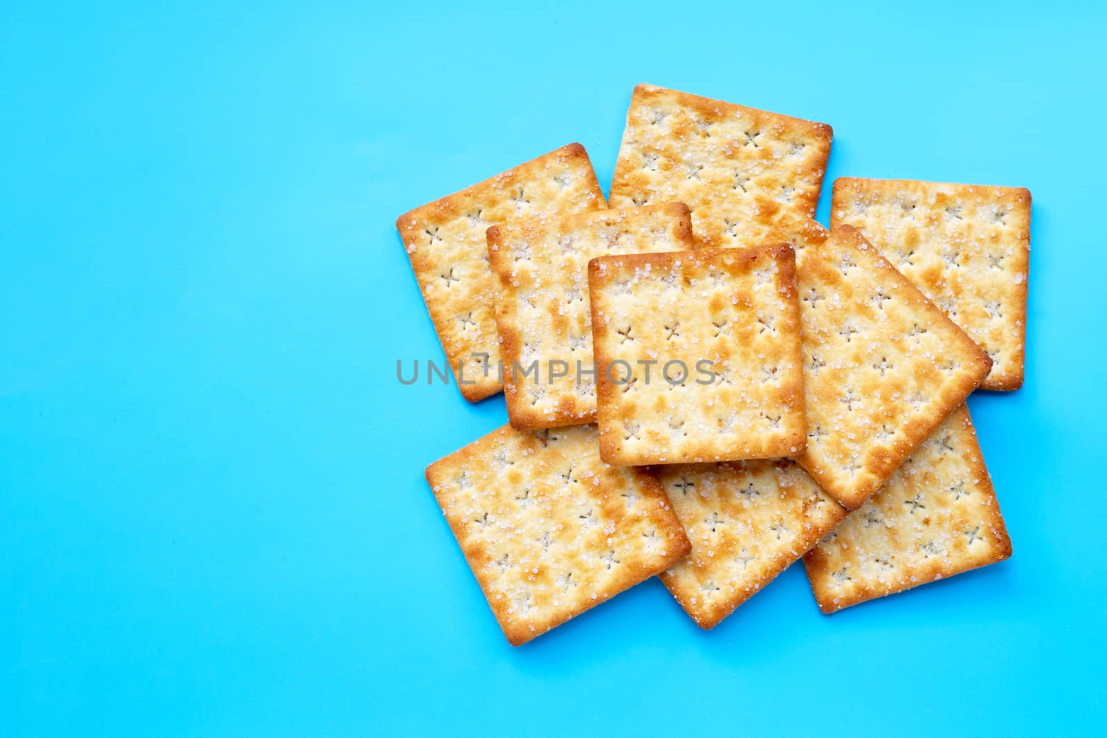 Crackers with sugar on blue background. Top view