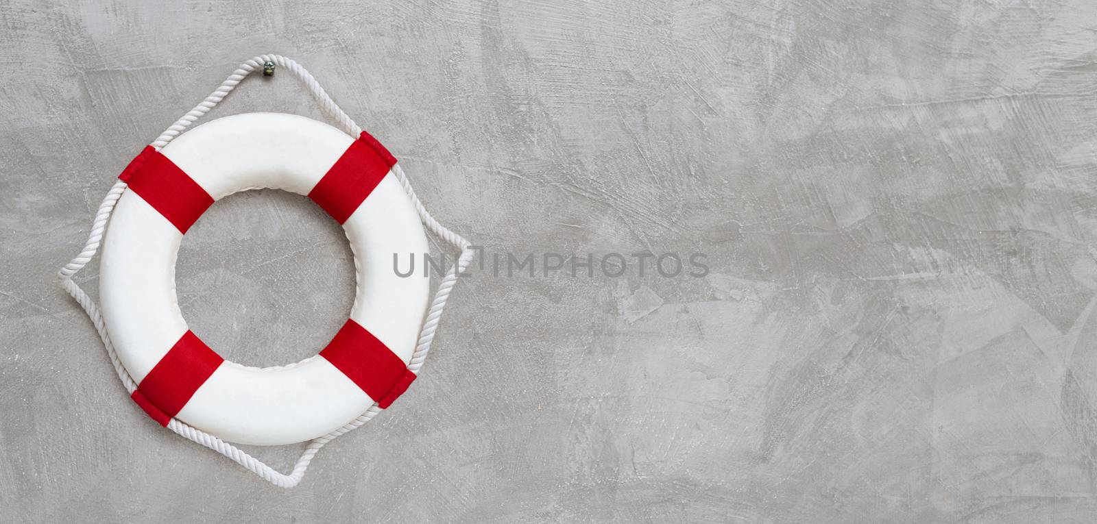 Lifebuoy on concrete wall background. Copy space
