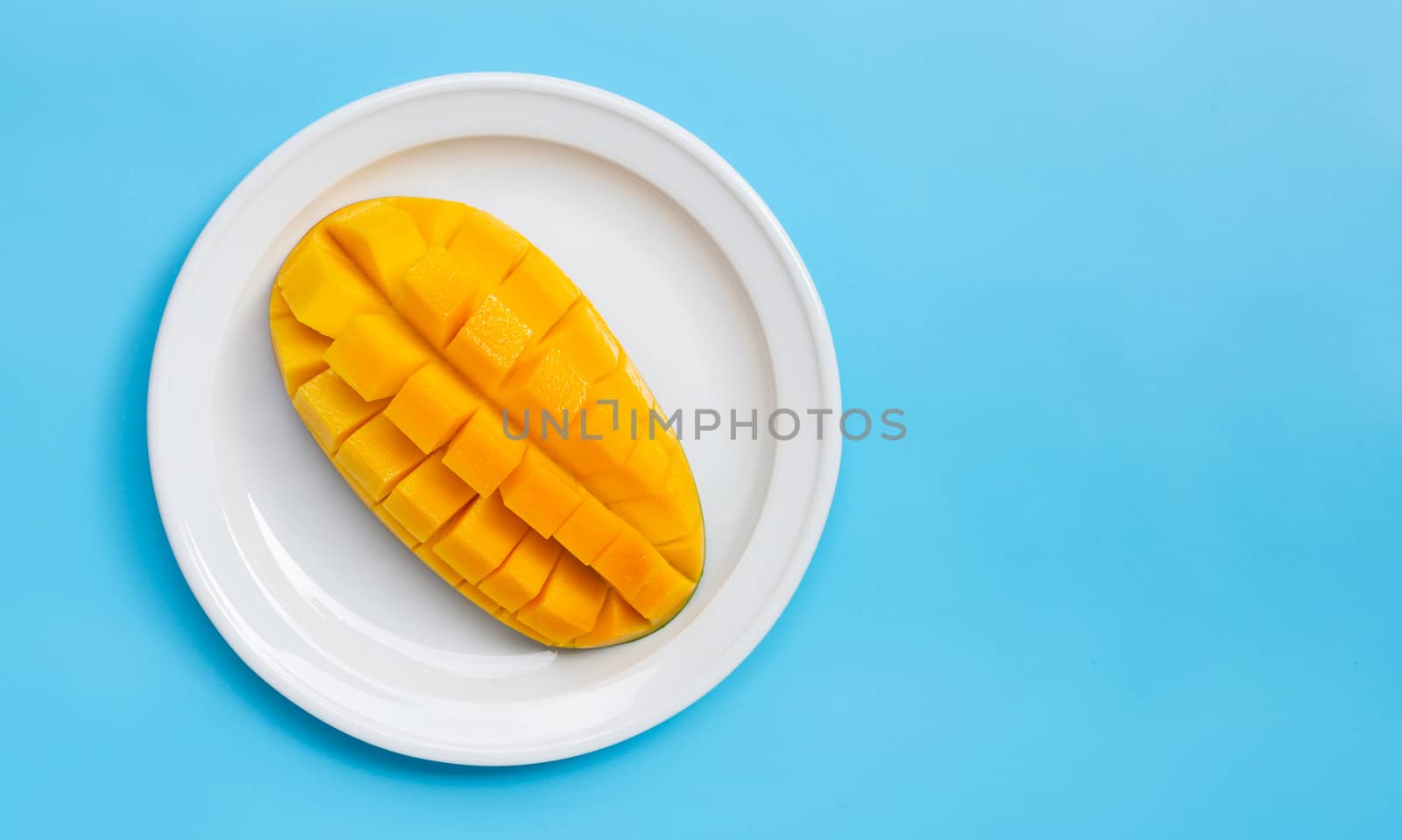 Tropical fruit, Mango on blue background. Copy space