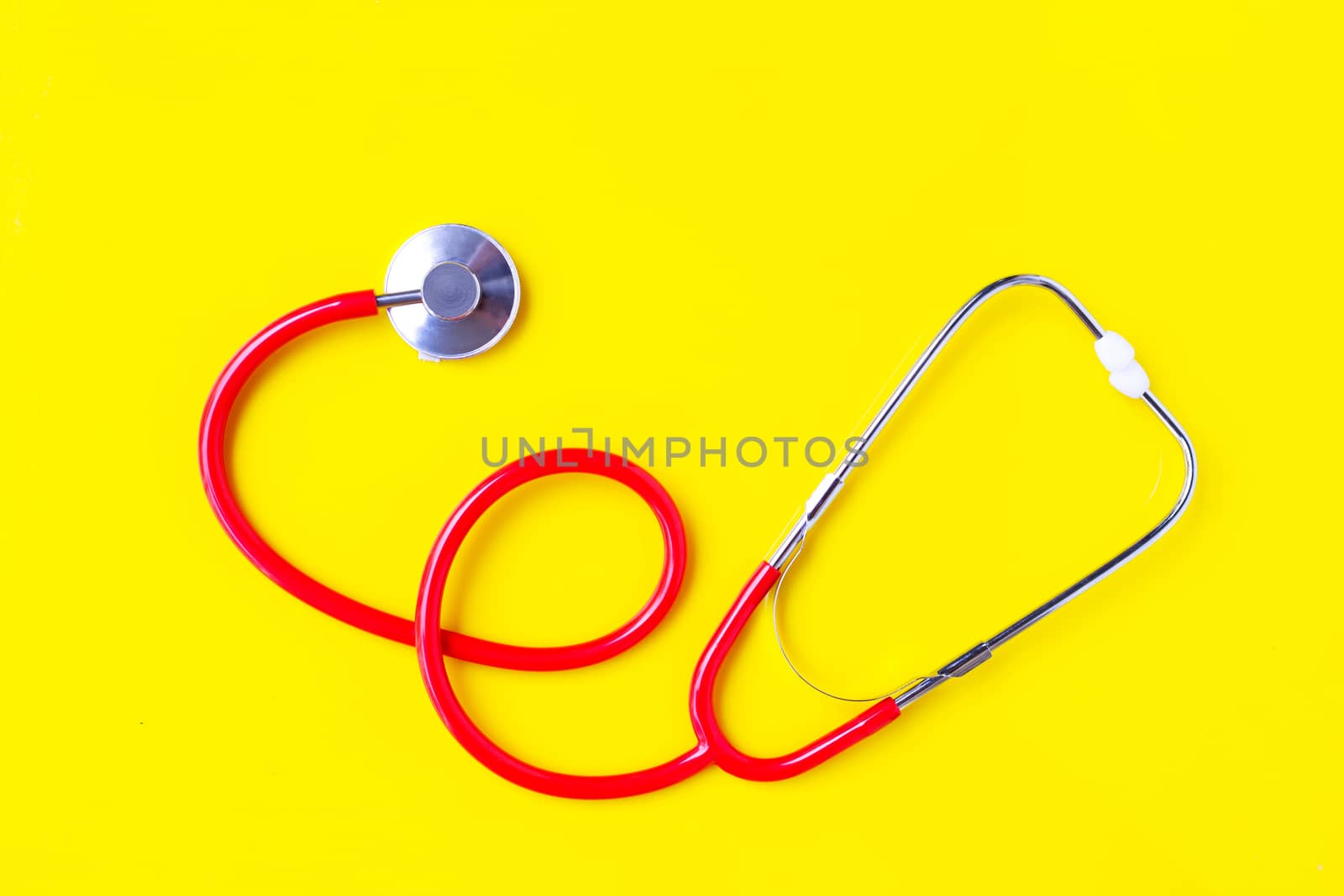 Stethoscope on yellow background with copy space