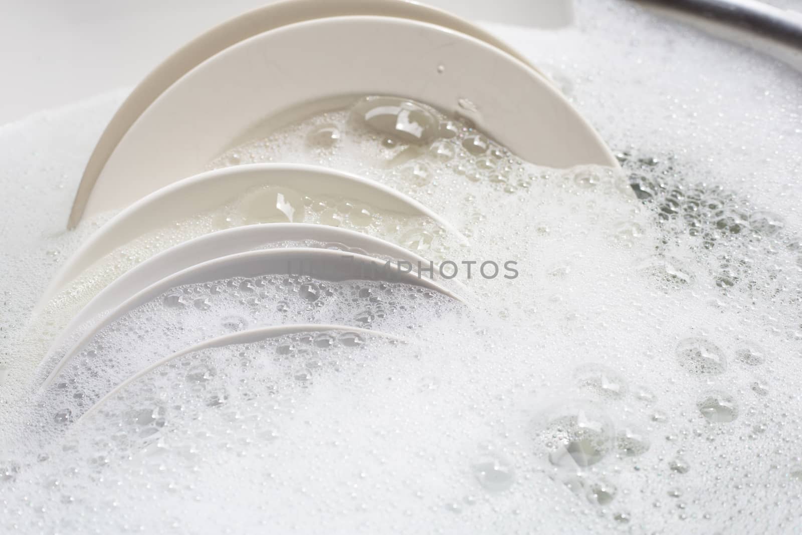 Dish washing, Dirty dishes soaking in kitchen sink.