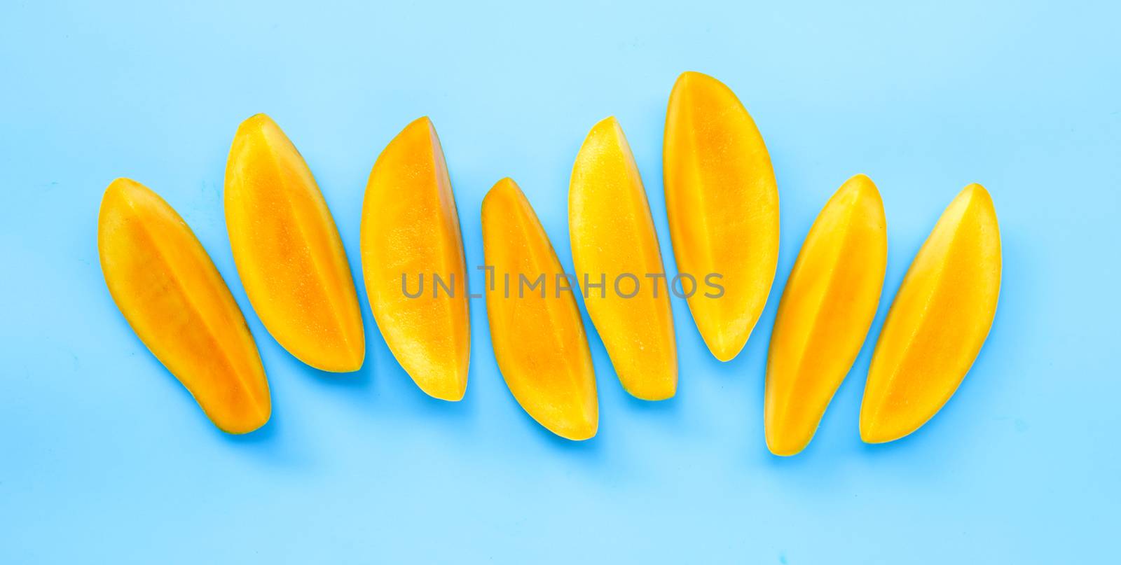 Tropical fruit, Mango slices on blue background. Top view