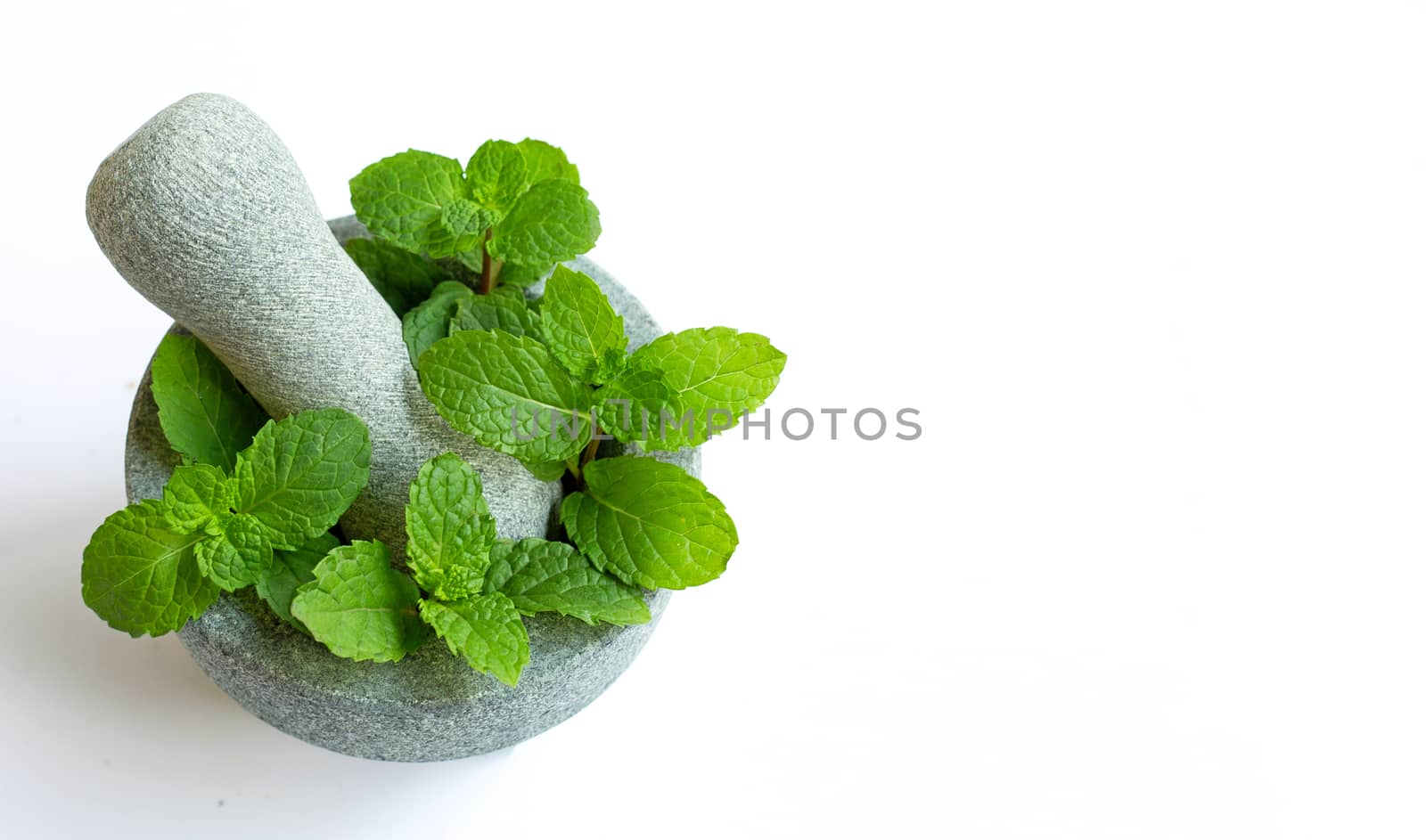 Mint leaves in stone mortar and pestle on white background. 