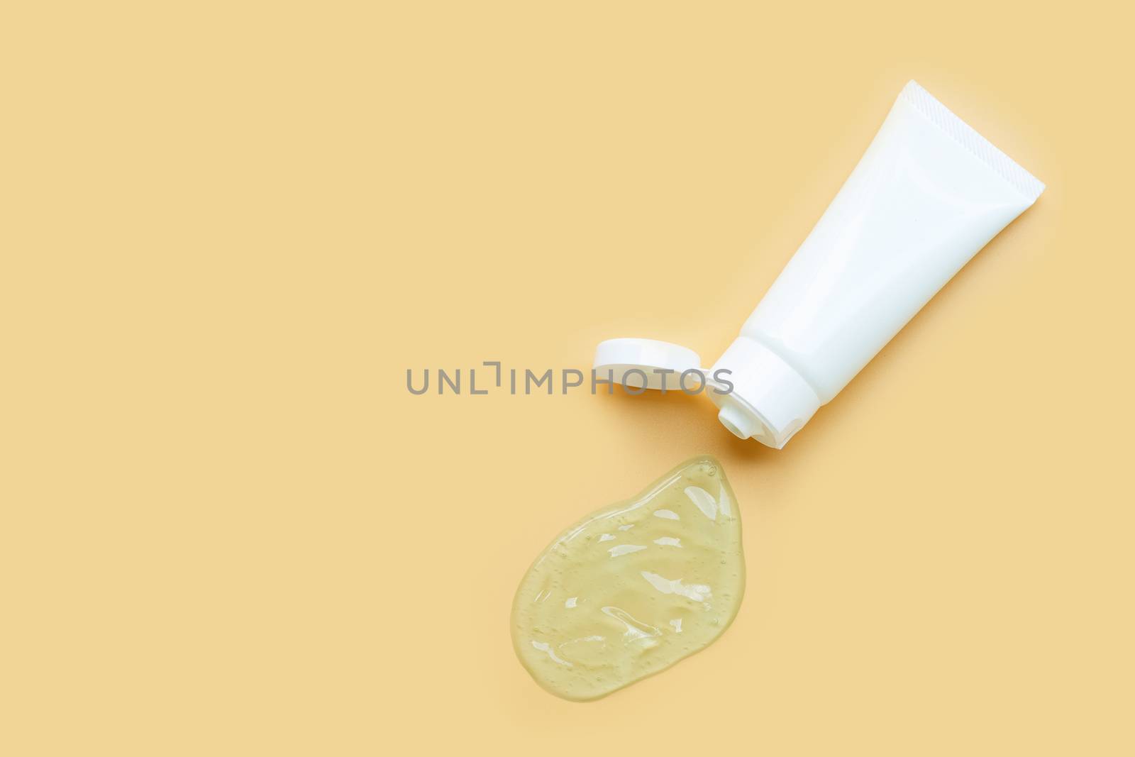 Alcohol hand sanitizer gel in white glossy plastic tube for hygiene corona virus (Covid-19) protection. Yellow background with copy space