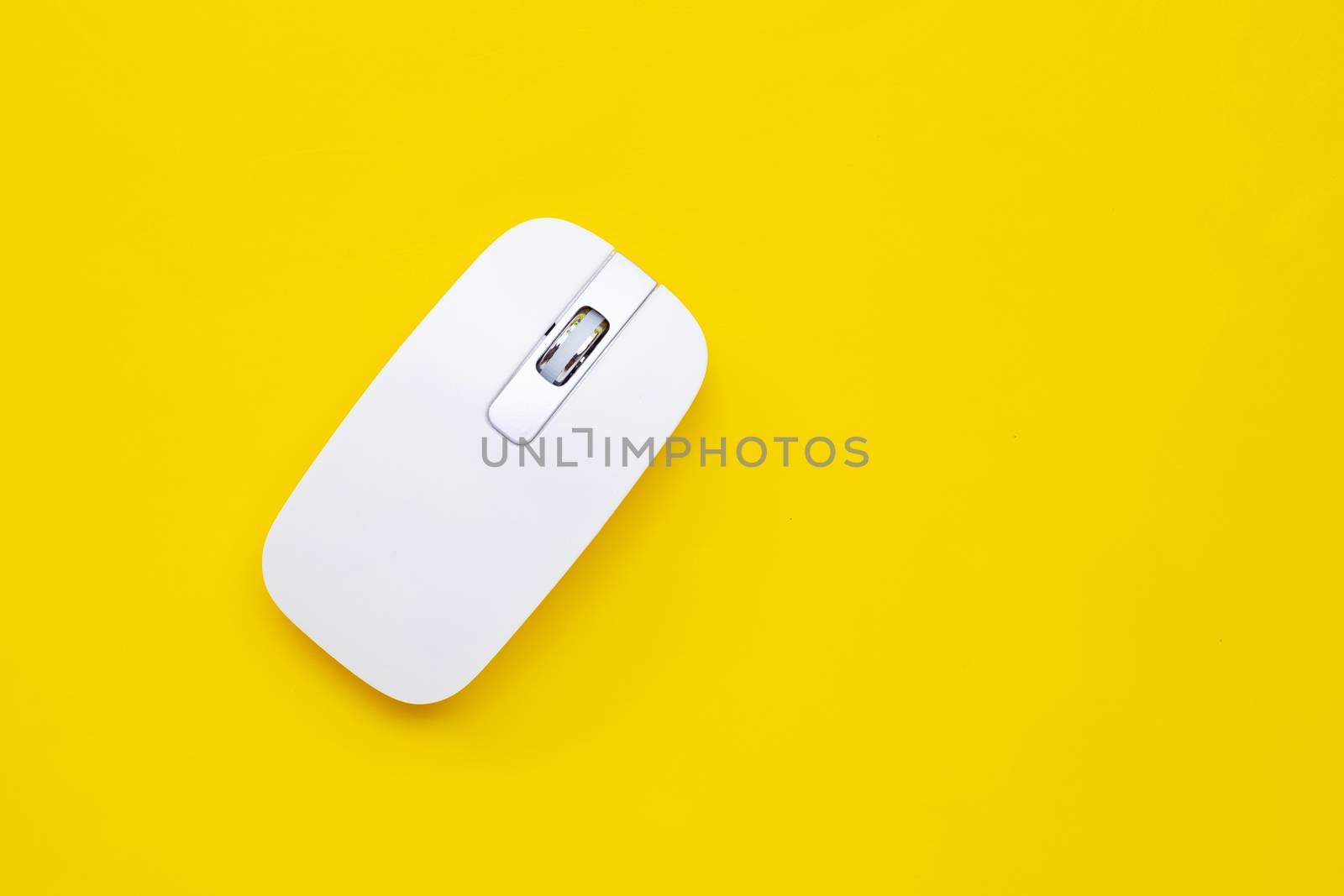 White computer mouse on yellow background. Copy space