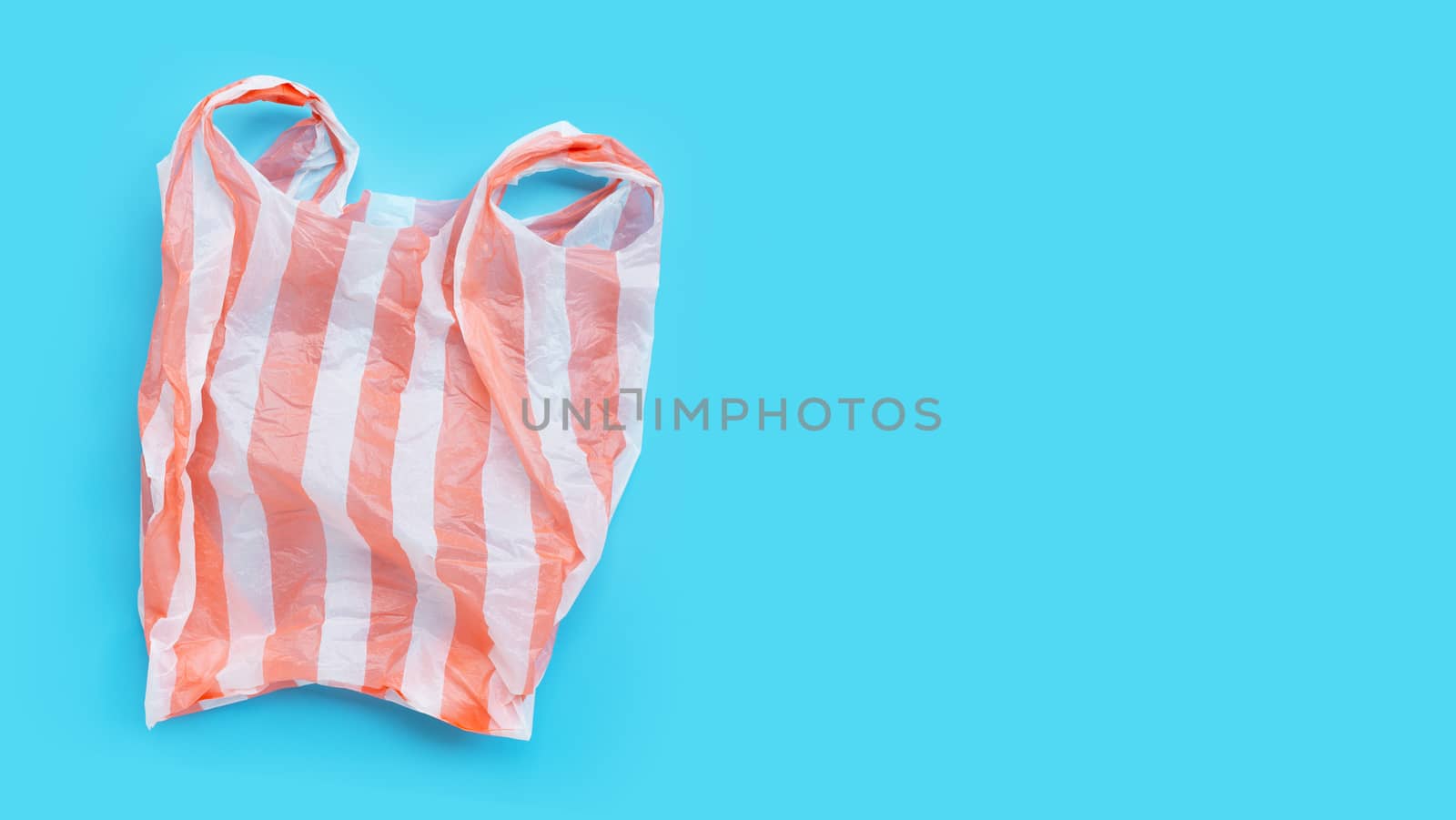 Colorful plastic bag on blue background. Copy space