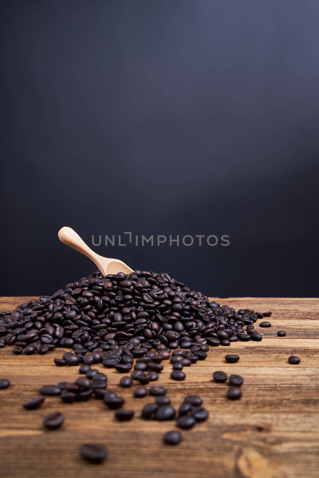 Wooden spoon put on pile of coffee bean black background by eaglesky