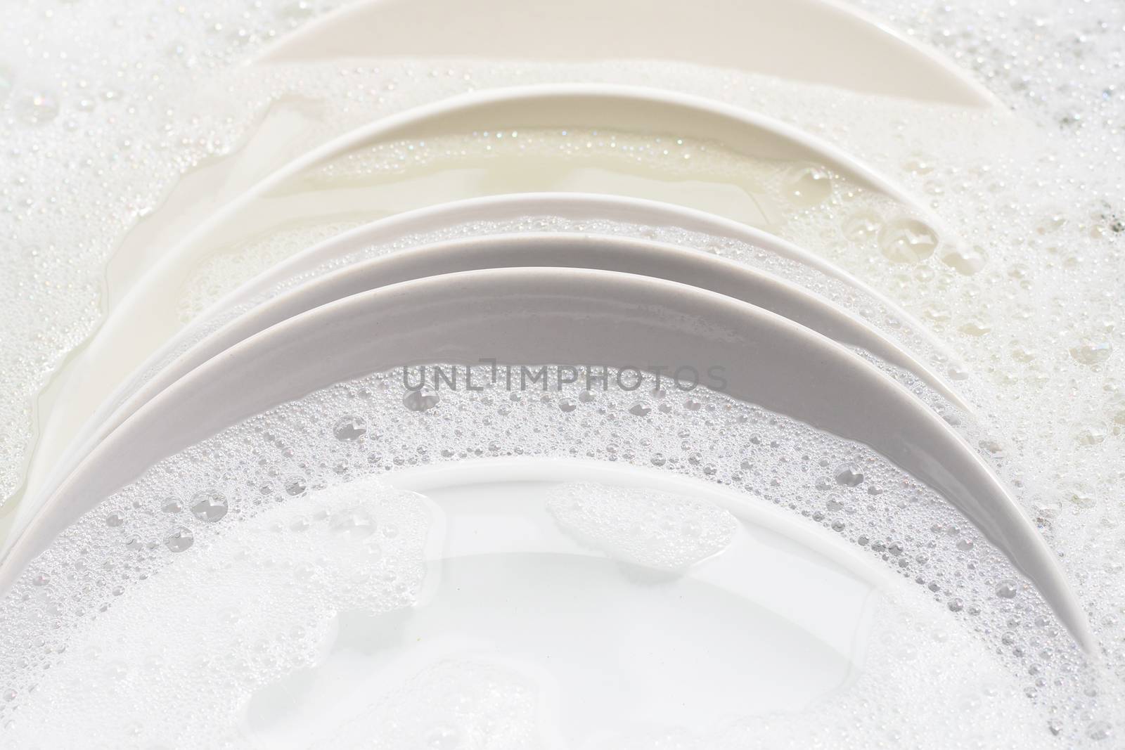 Dish washing, Dirty dishes soaking in kitchen sink.