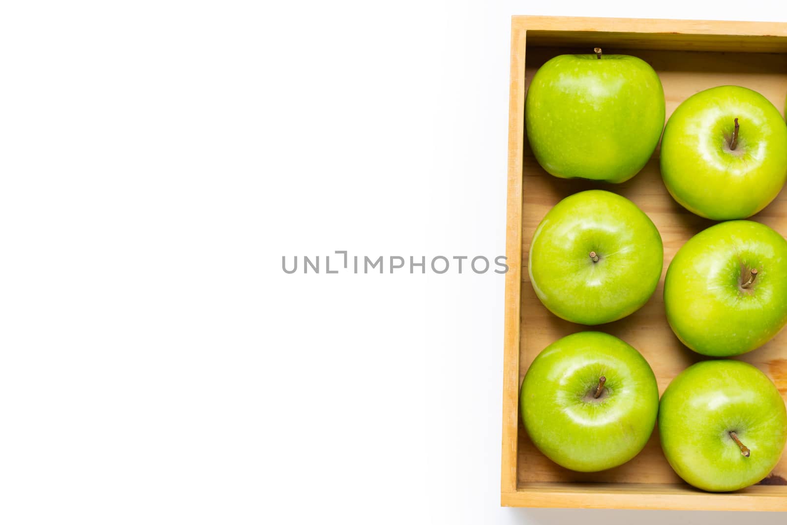 Ripe green apples in wooden box on white background. Copy space