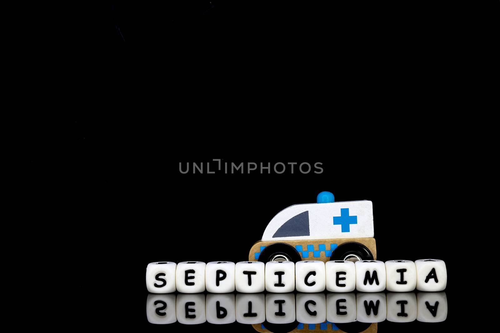 Alphabet letters spelling the word septicemia with a model ambulance in the background. A concept of serious medical disease which requires prompt medical attention.