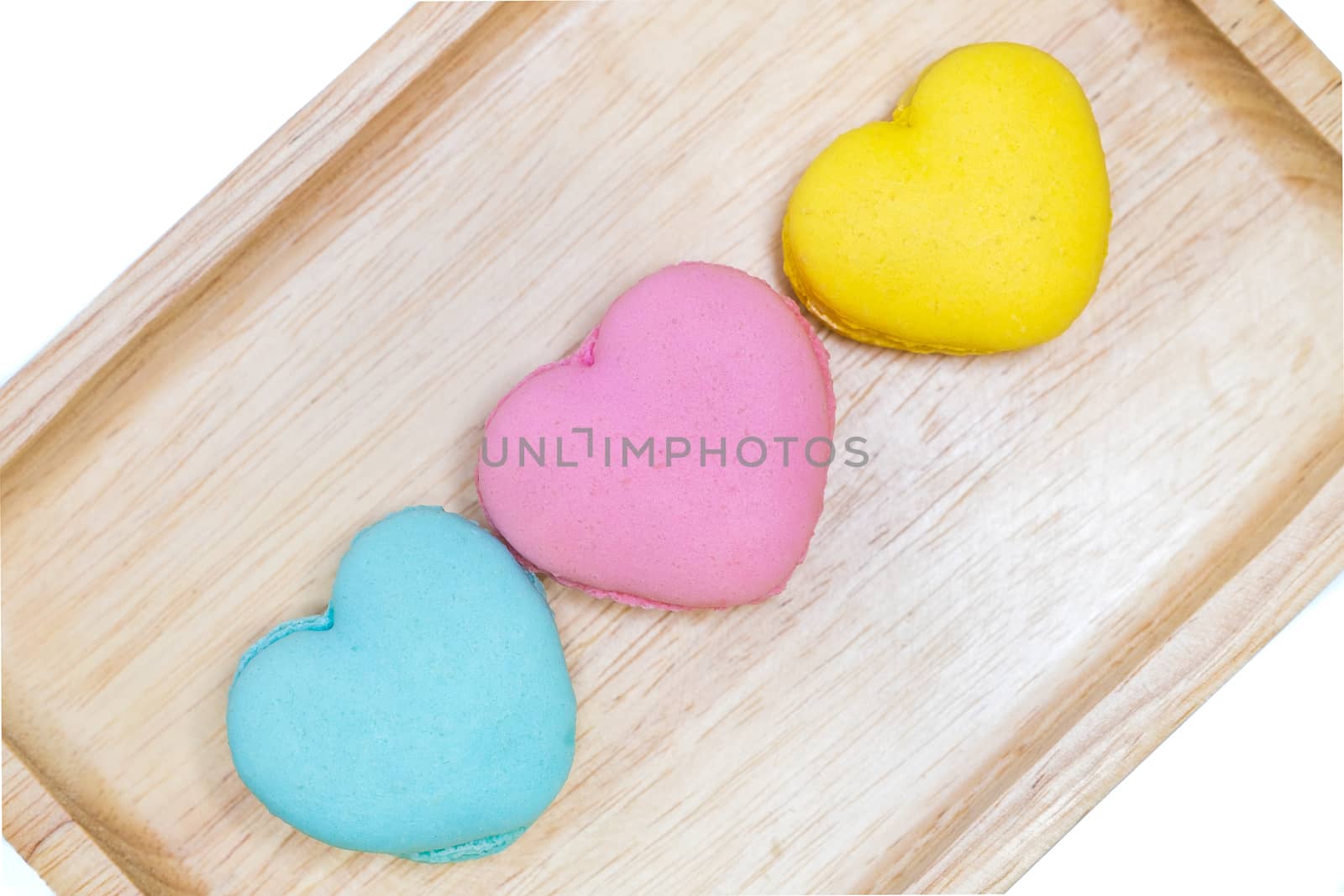 multi colored macaroons on a wooden trey, top view