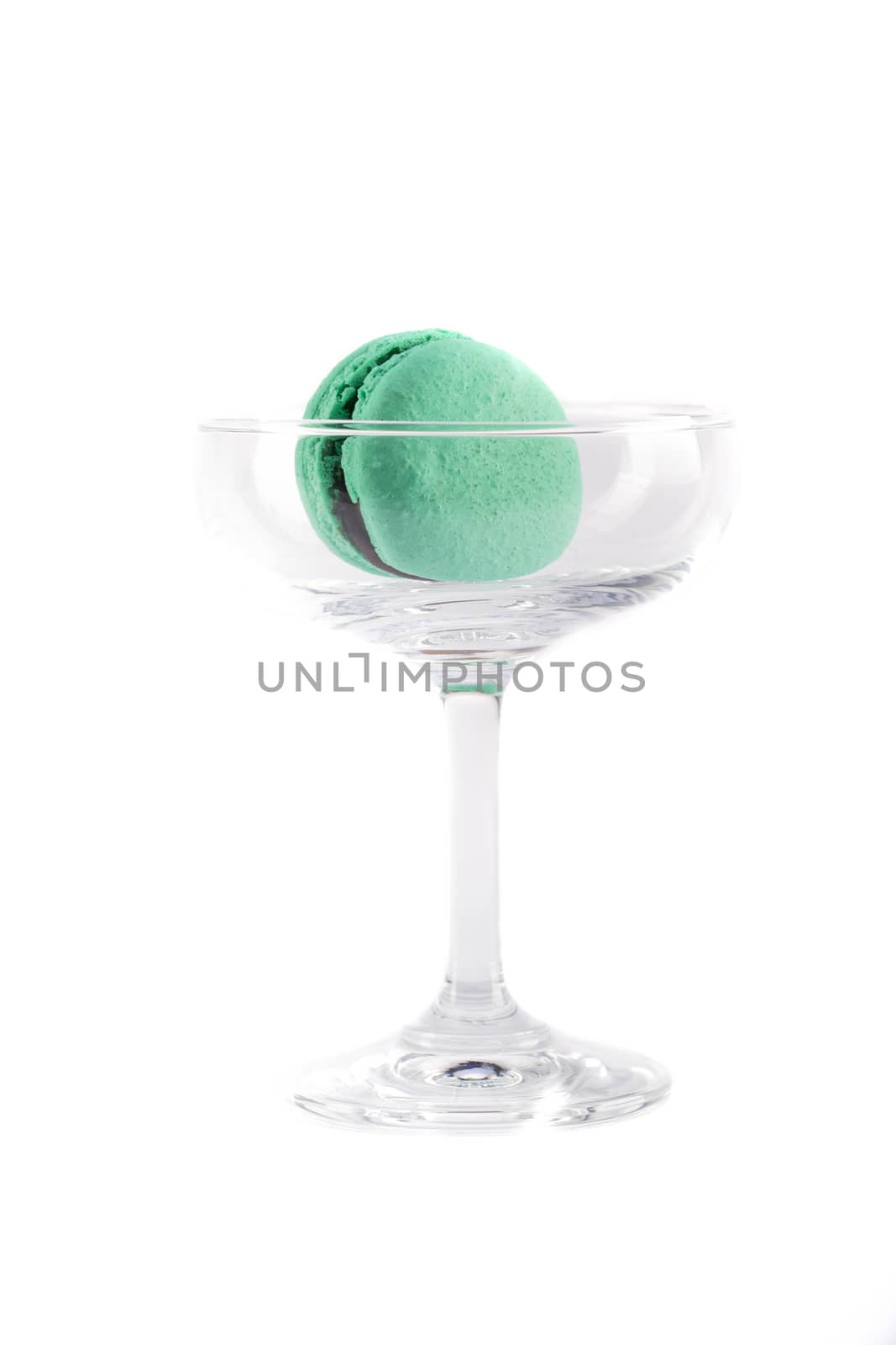 a mint flavored macaroon with chocolate filling in a clear glass, isolated on white background