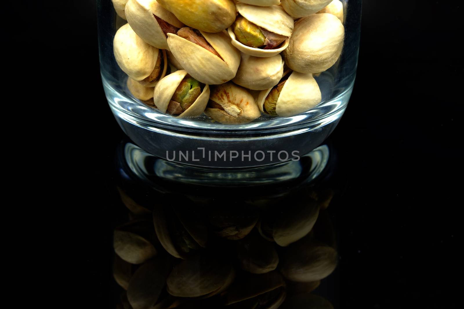 roasted pistachio in a clear glass bottle, close-up details