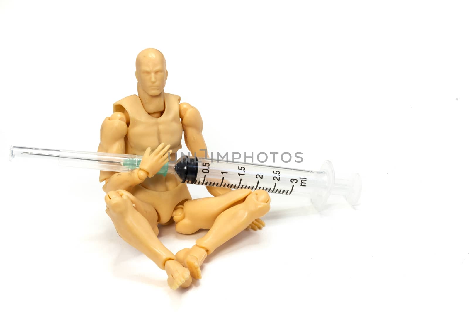 a plastic model holding a needle and a syringe in his hands, drug use or dependent concept, on white background