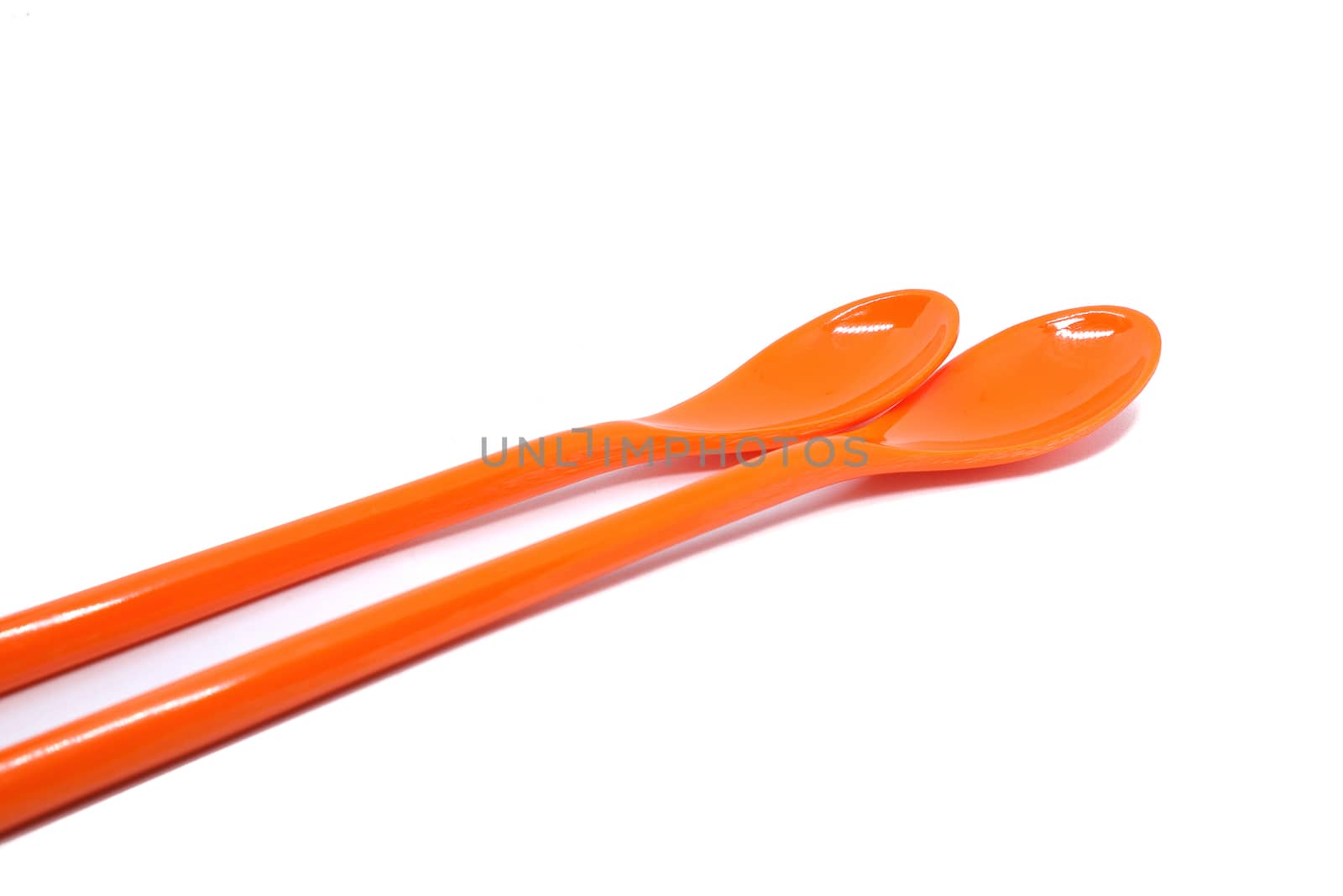 orange plastic spoons, isolated on white background