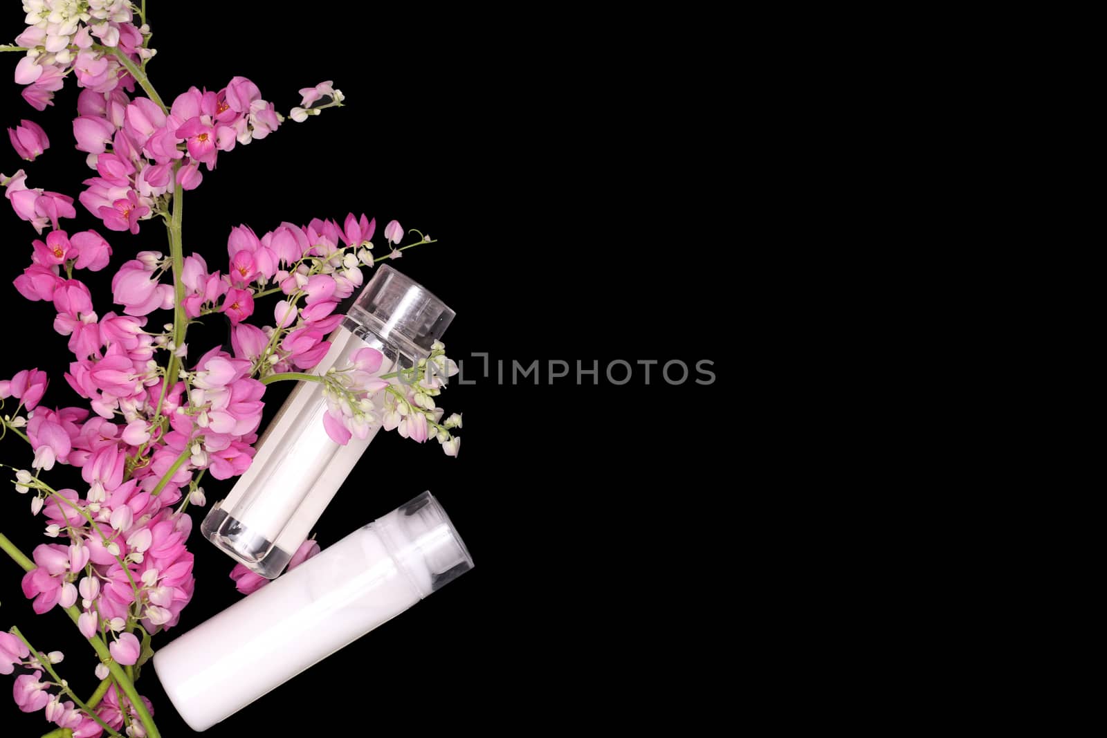 pink flower climbers with shampoo and conditioner bottles on black background, shower, spa, concepts