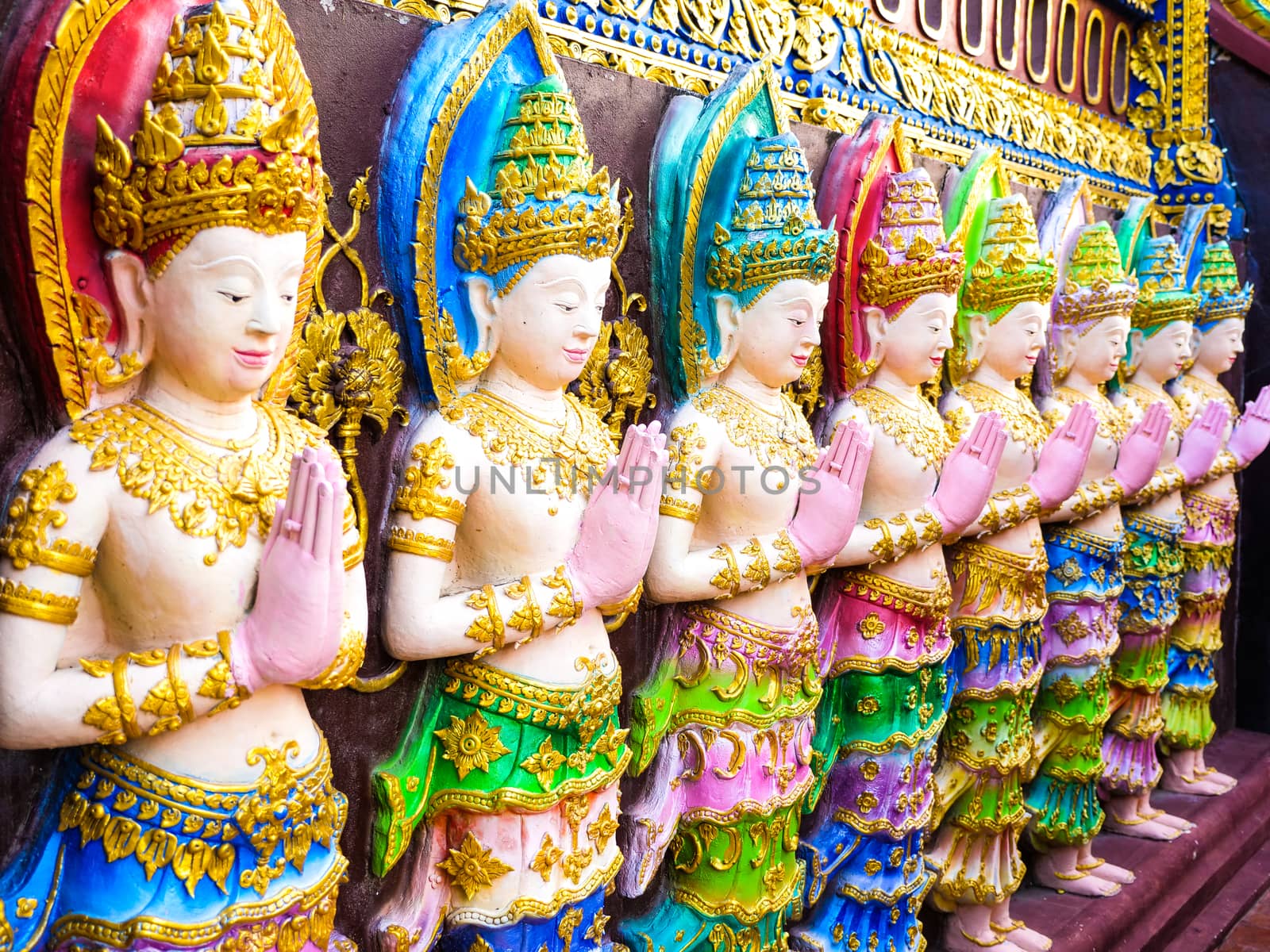 a colorful scalptures of standing male angles on a temple wall