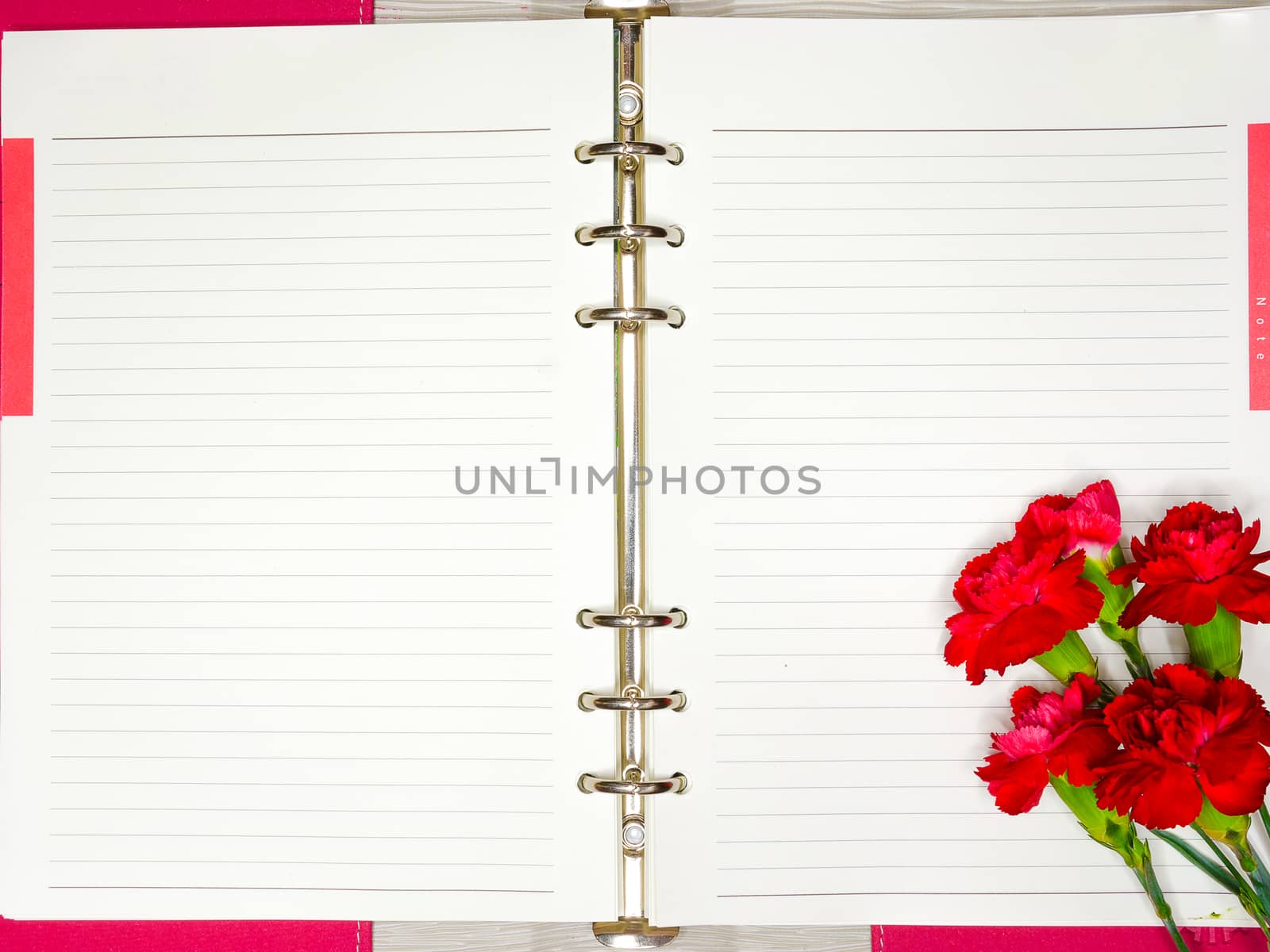 a blank notebook and a bunch of red flowers with empty space