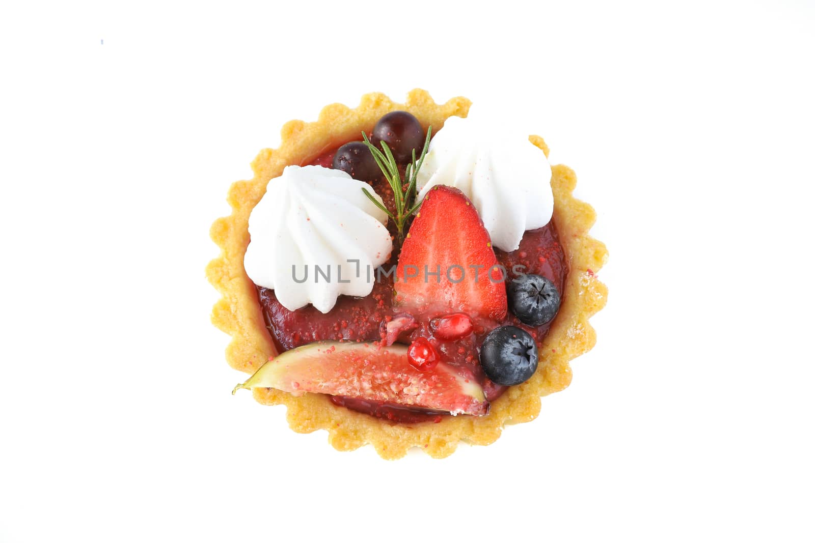 Mixed fruits tart with fig, promegranate, starfruit, cherry, blueberry, grape, and raspberry jam. A cup of tea, brown wooden background, top view.