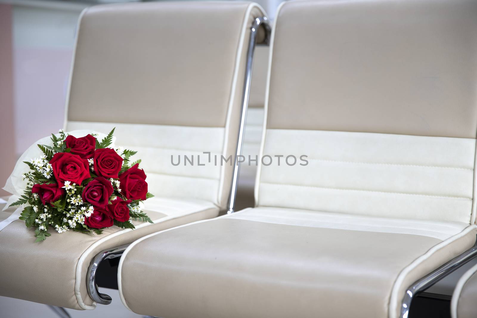 bright and beautiful blooming large roses with small delicate white flowers bouquet on a row of model style chairs, love romance wedding minimalism concept