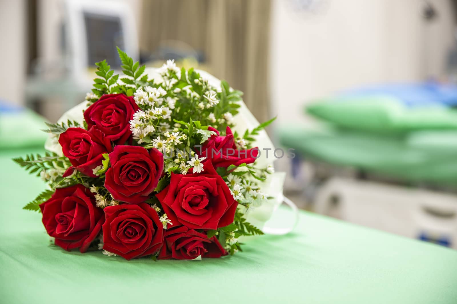 a bouquet of red roses on a hospital bed. Blurred hospital environment background. Medicine concept.