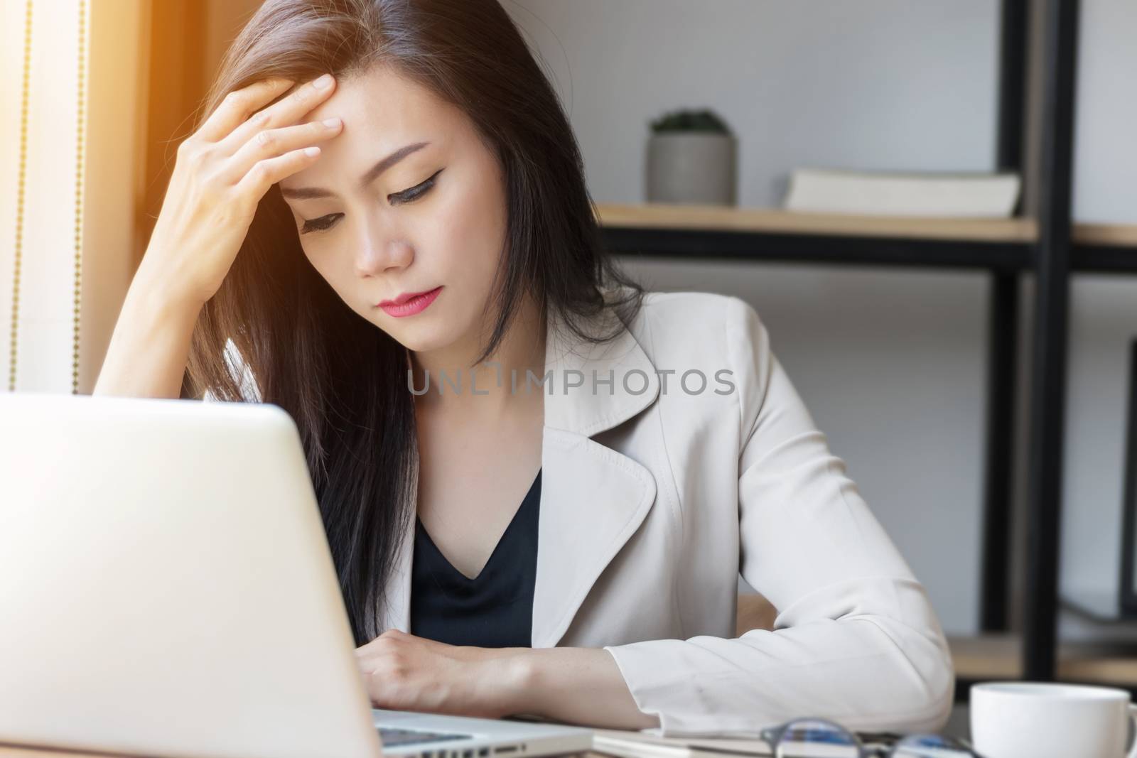 young Asian stress woman at work, depressed woman in the office. portrait of beautiful young Asia female feeling sick, having headache, office syndrome. healthcare at work place concept