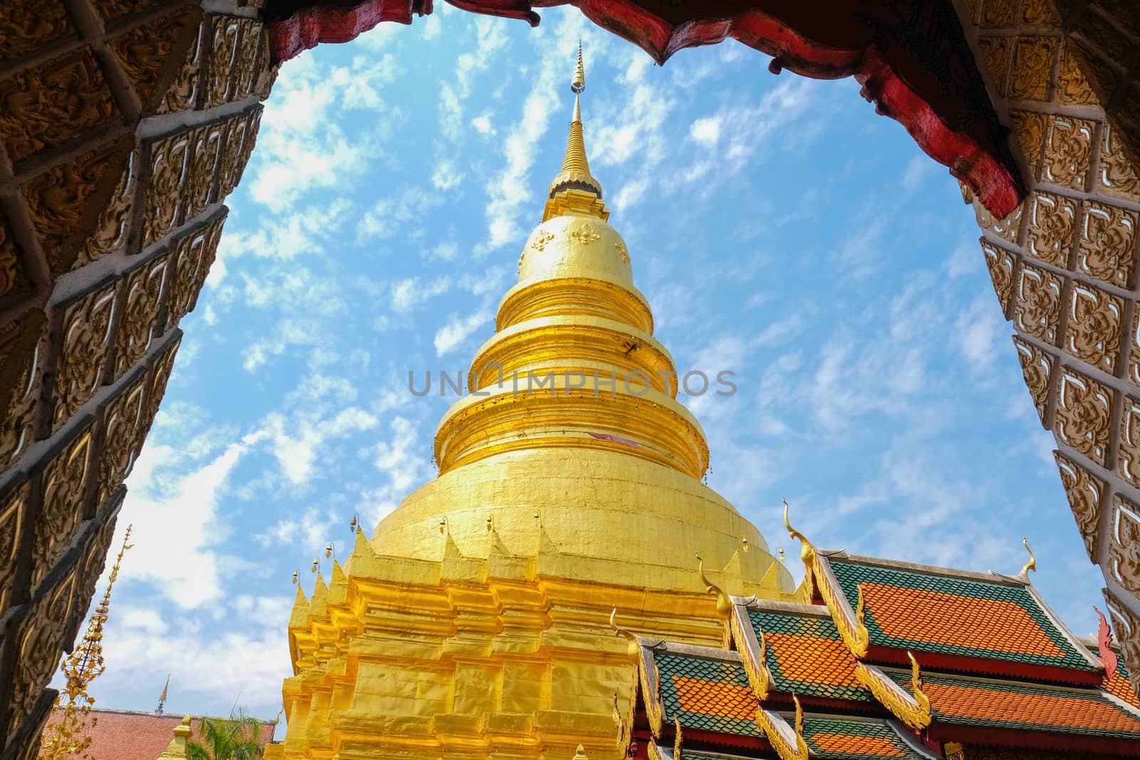 a golden pagoda at Wat Phar Thai Hariphunchai by Nawoot
