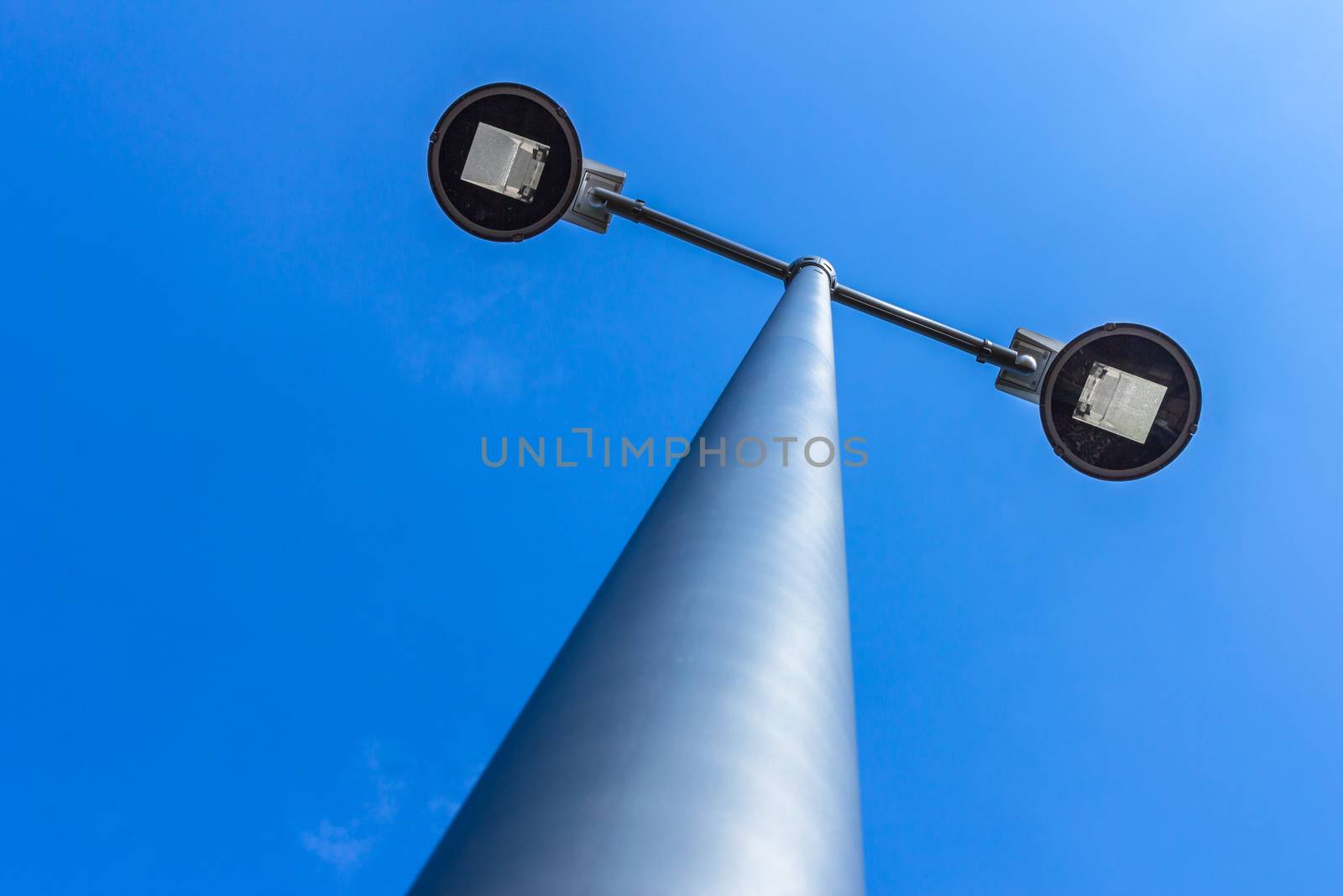 Double modern street light lamp on a blue sky background. Bottom view.