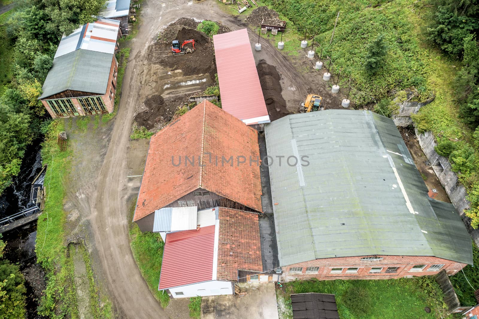 Renovation of old factory buildings from the 19th century, aerial view, with forest in the background