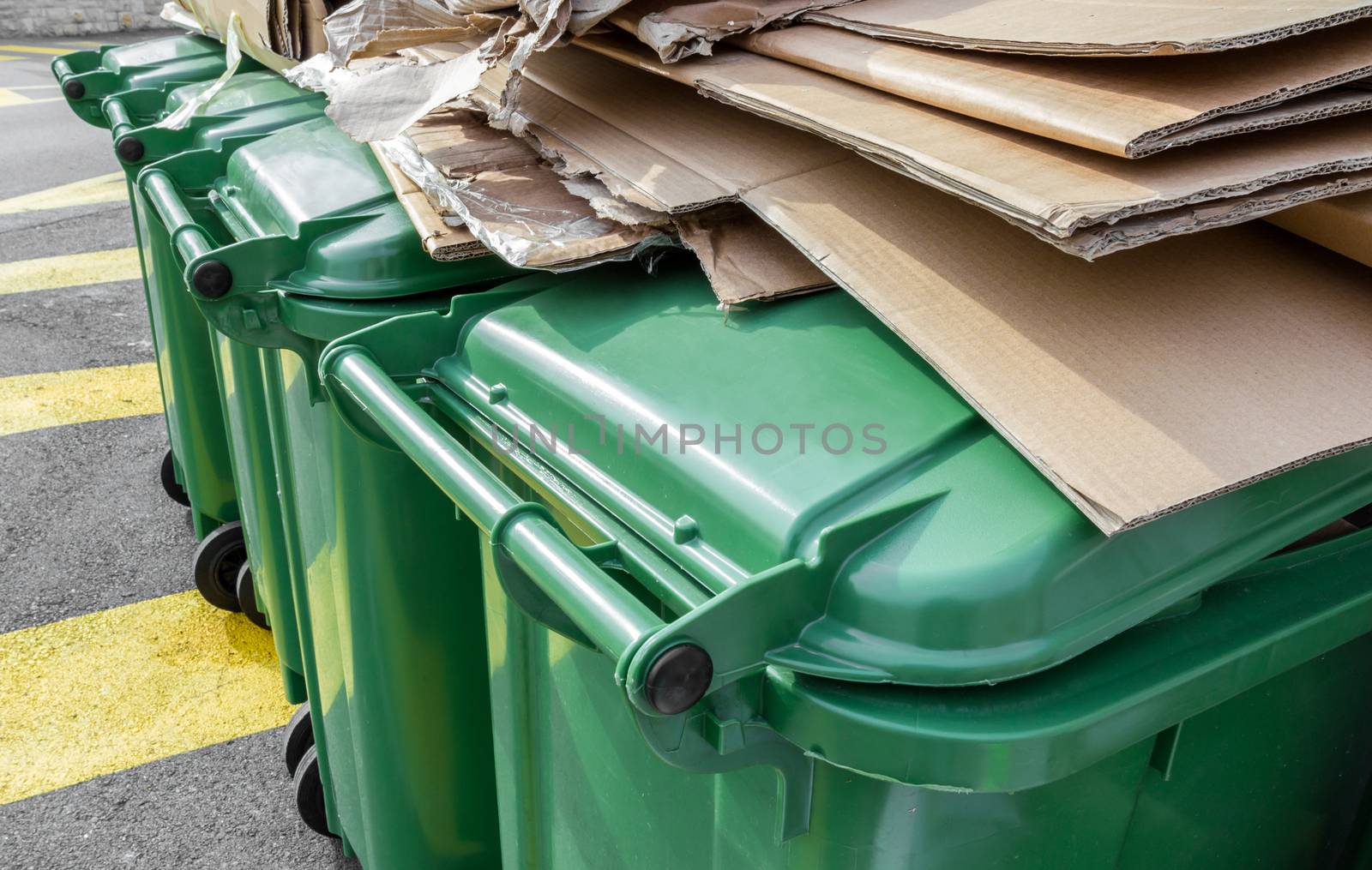 Paper and cardboard on green recycle bins