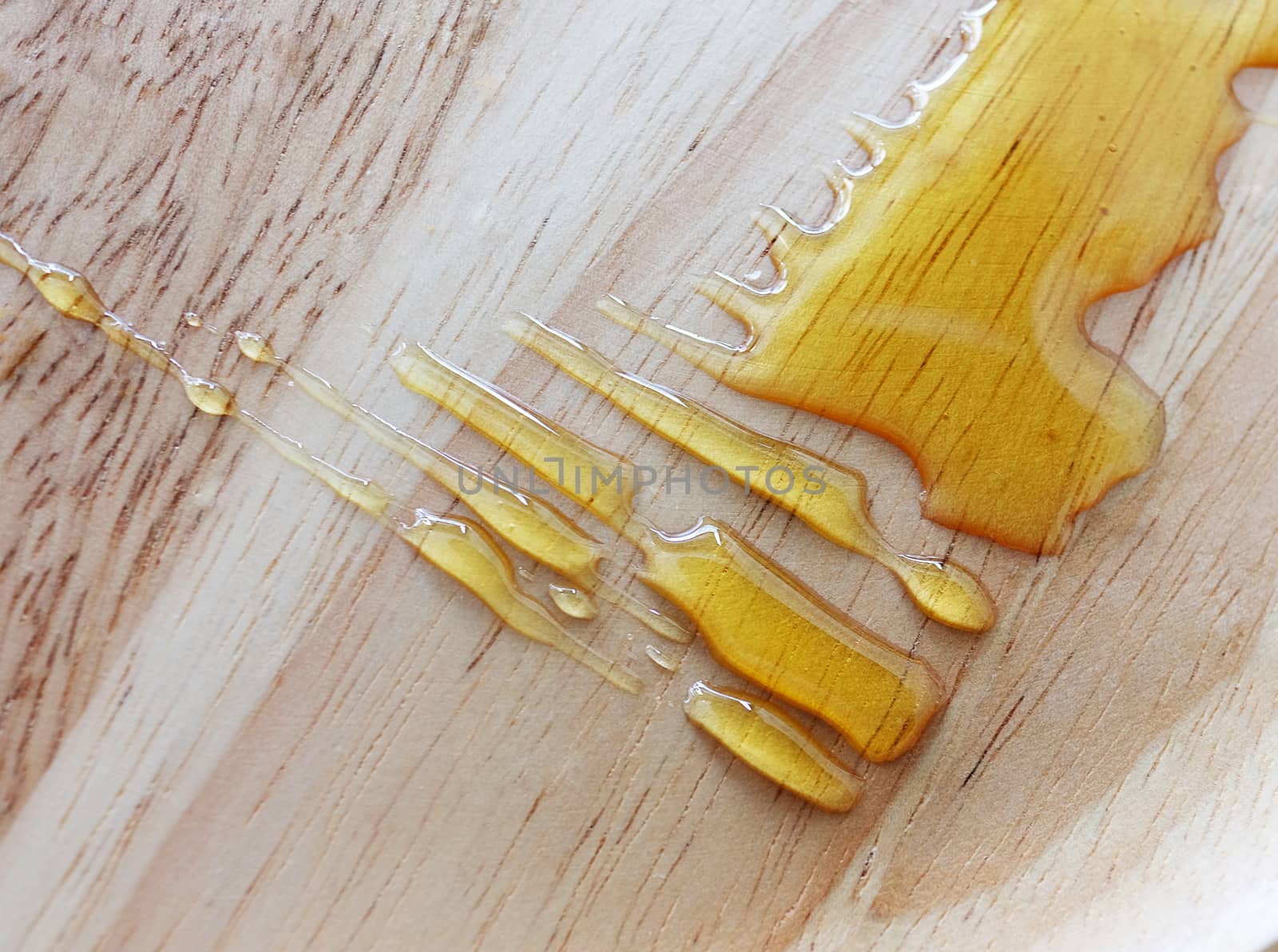splas of honey syrup on top of a wooden table