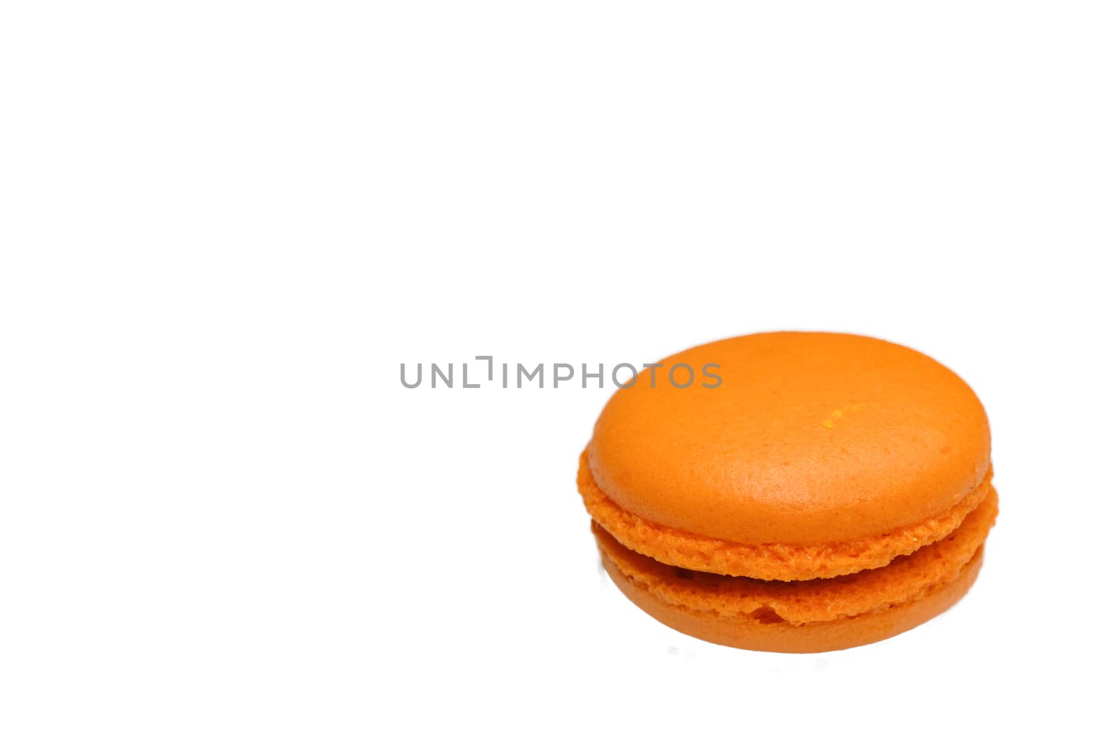 an orange flavored macaroon with chocolate filling, macro top view clean minimal style, isolated on white background