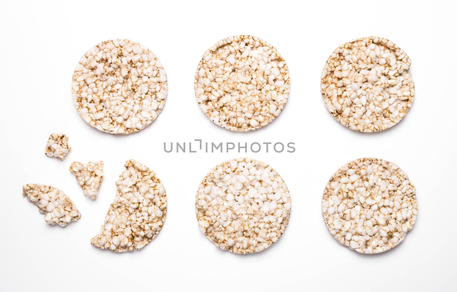 Six rice and spelled cakes isolated on white. One is broken. Concept of healthy eating and diet.