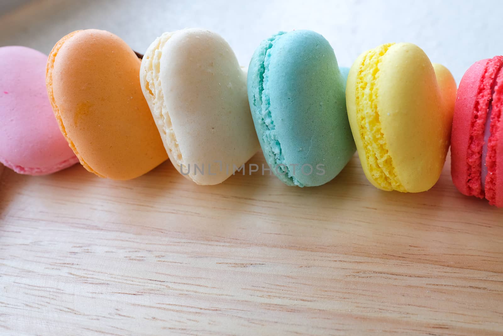assortments of colorful heart-shaped macaroons on a wooden tray