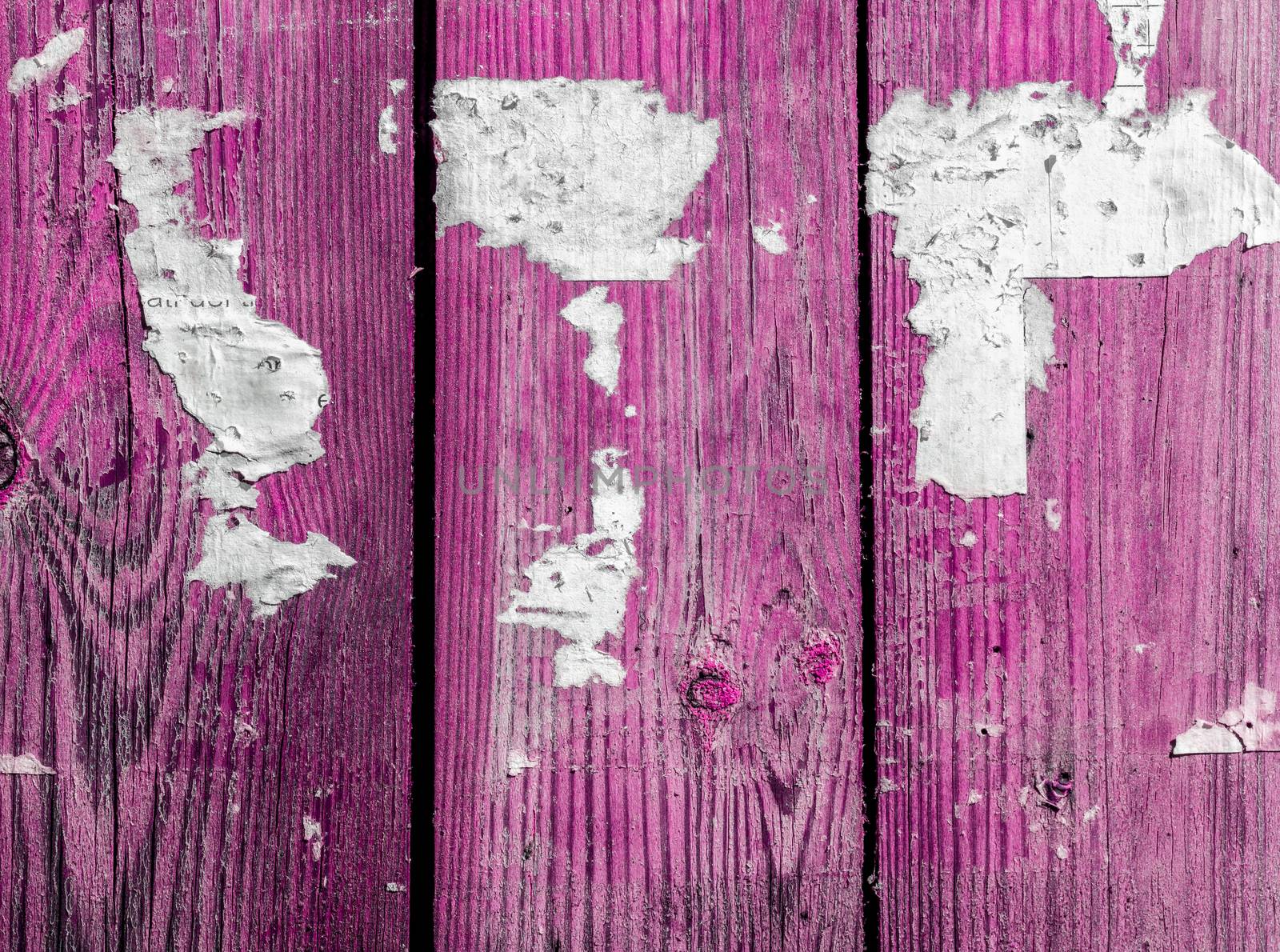 Wooden abstract background with light, scratches and newspaper pieces.