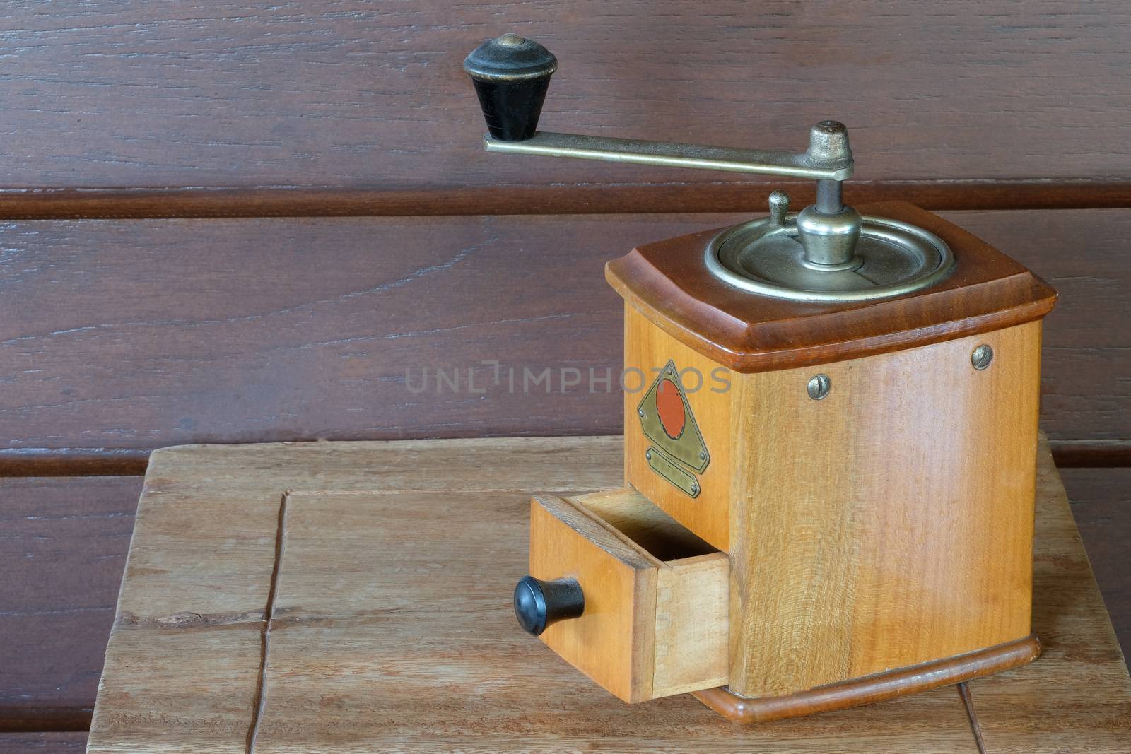 a vintage coffee grinder with wooden container, on wooden background
