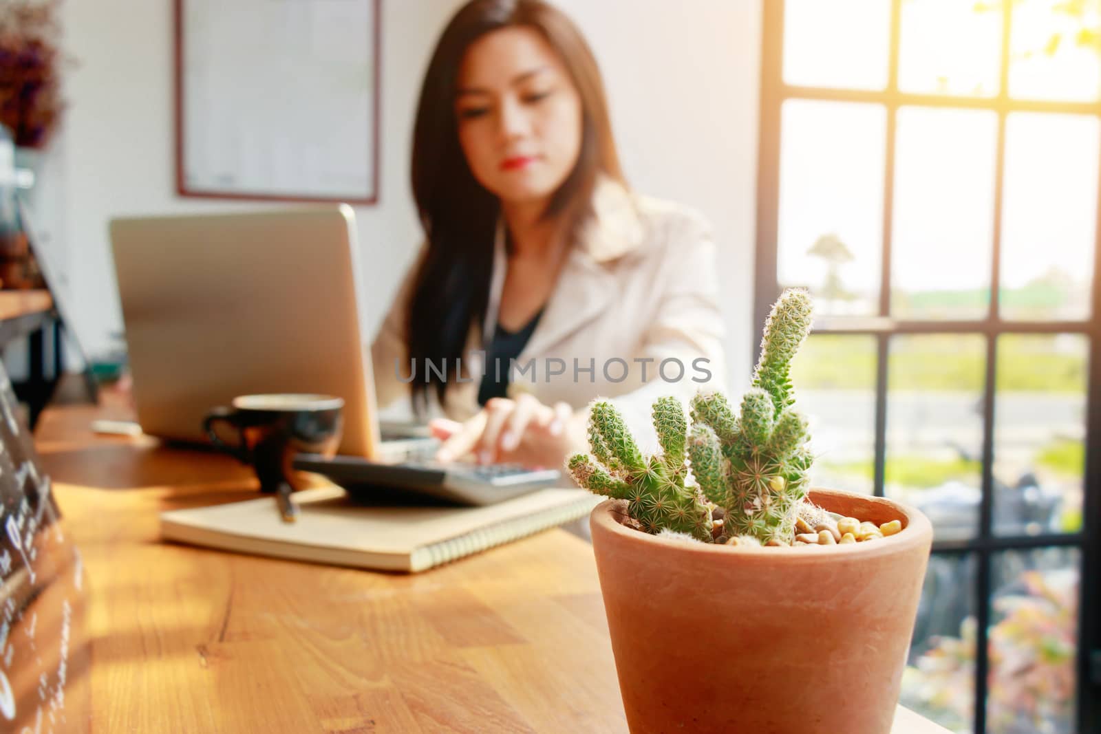 Asian business woman using calculator for accounting and analyzing investment in front of computer laptop at office workspace.  banking , savings , accountant , finances and economy concept. by asiandelight