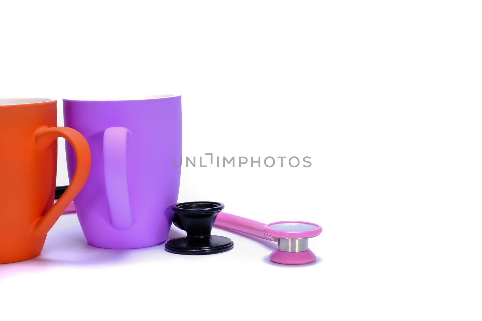 Two stetchoscopes and two ceramic coffee mugs isolated on white background, front view