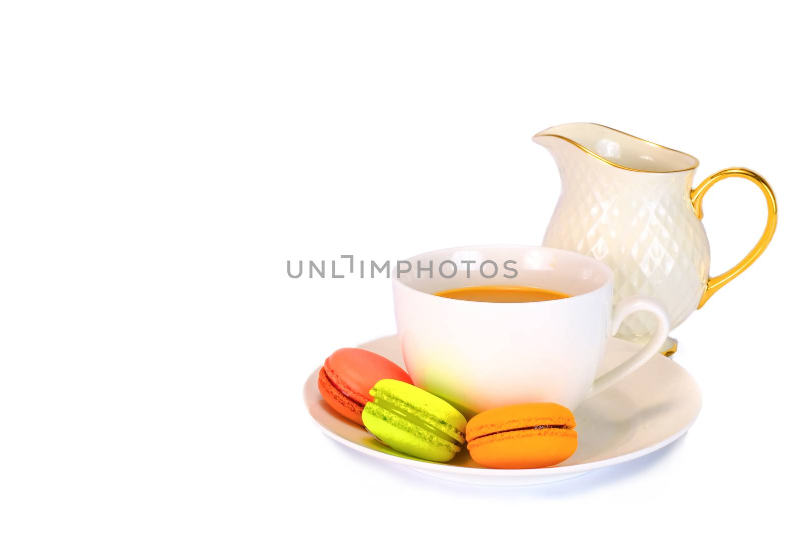 a white tea cup, a plate, and a milk jug with three colorful macaroons, an elegant aftertoon milk tea set, isolated on white background