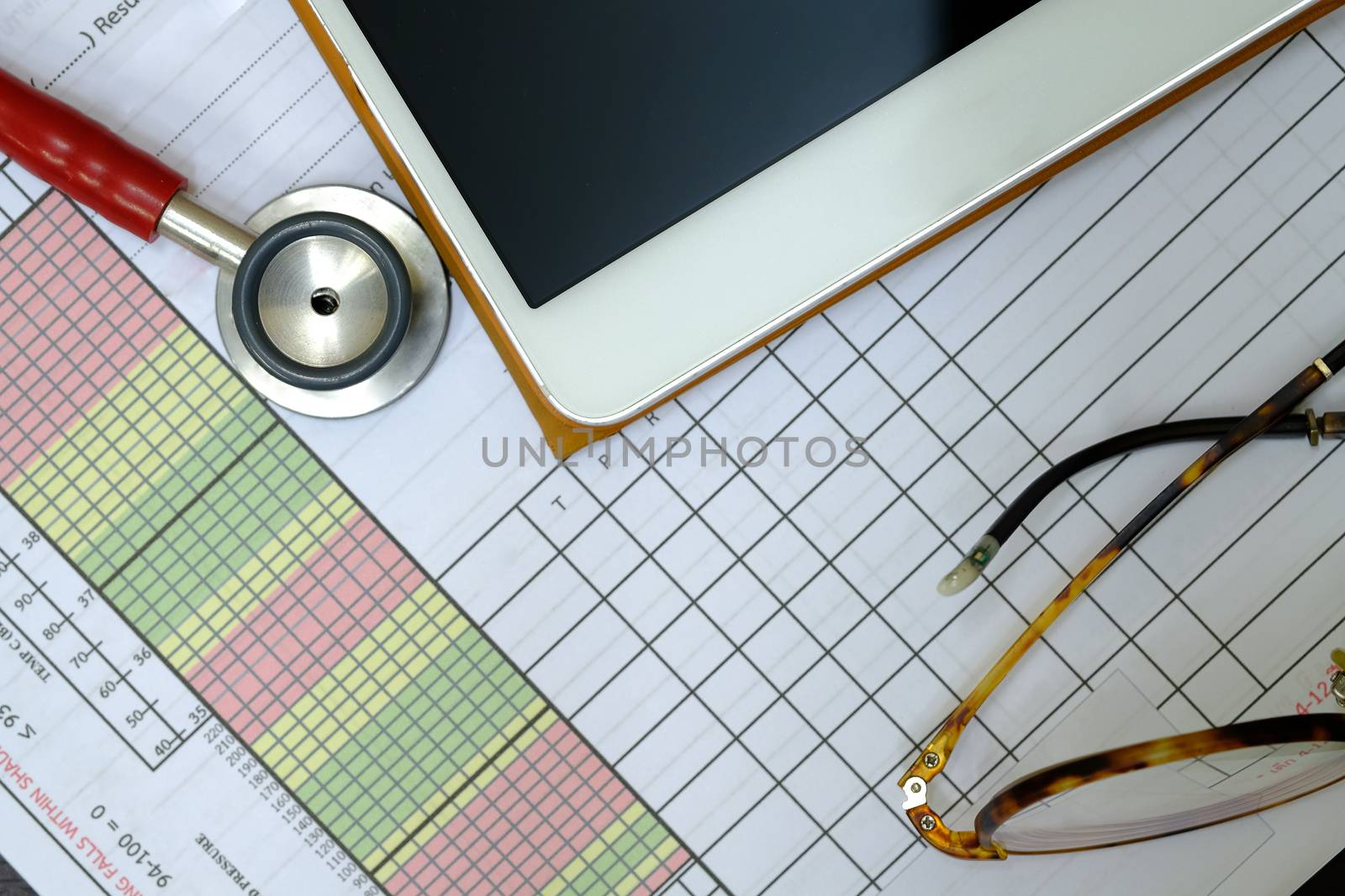 a red stethoscope, a patient vital sign sheet, a tablet, and a doctor's eyeglasses, top view, medical note concenpts