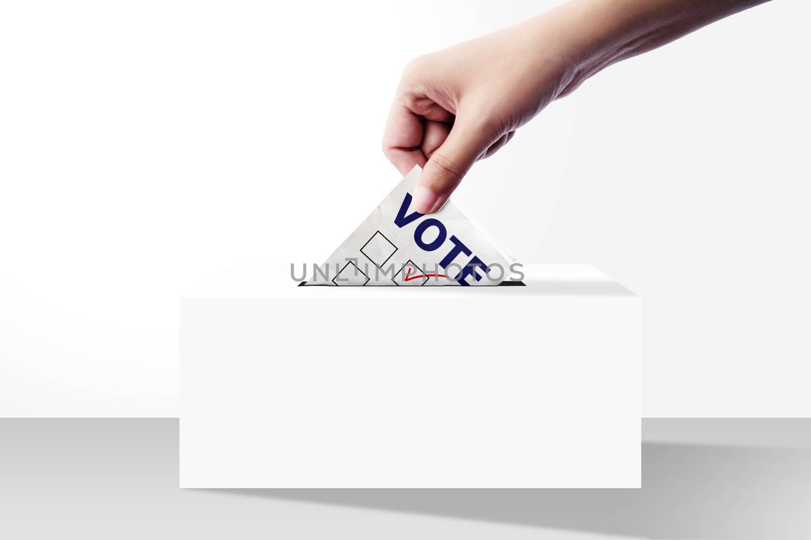 close up of hand holding voting paper for election vote into the ballot box on white background by asiandelight