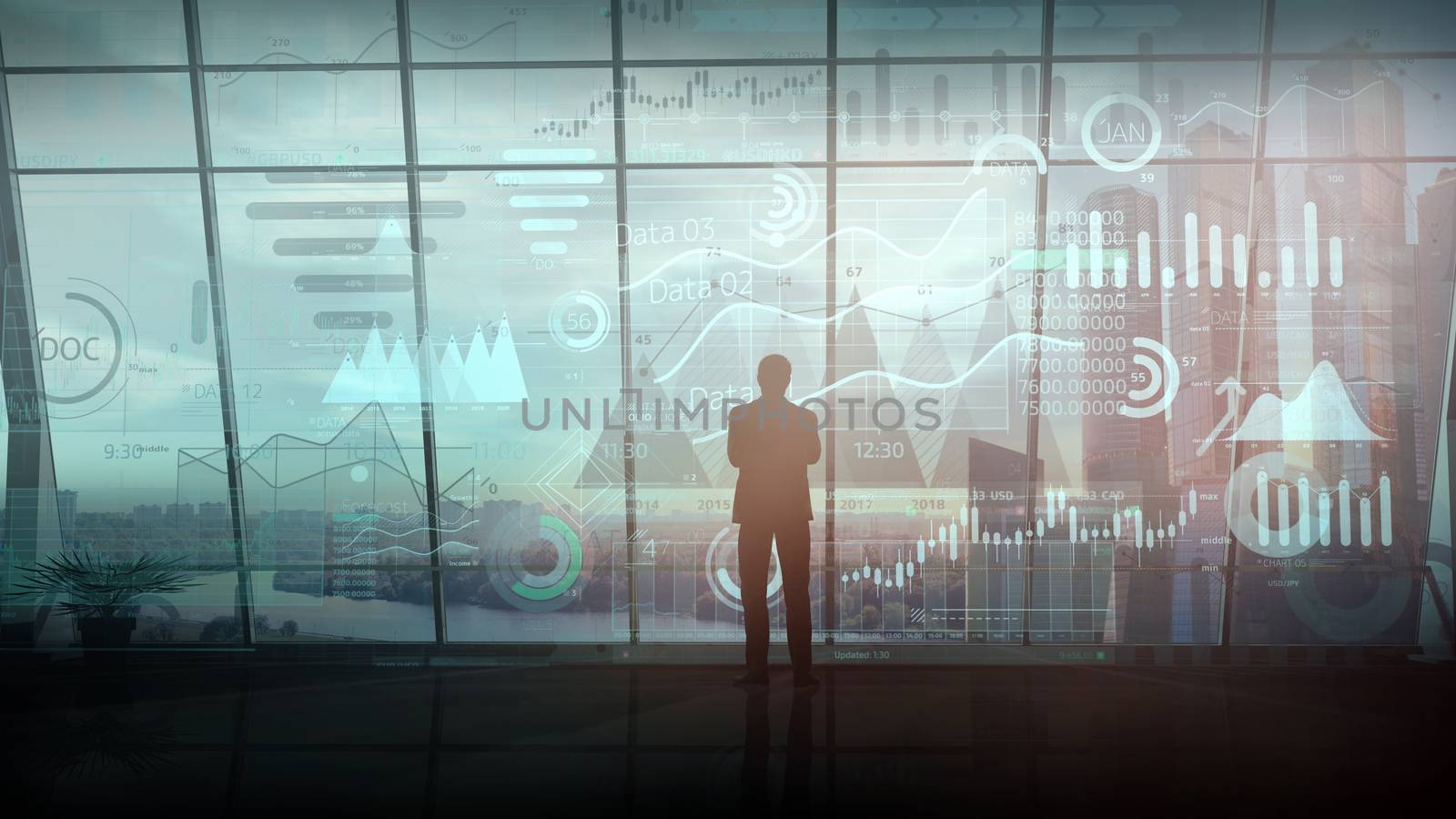 A businessman stands in a large office building and works with a large array of infographics.