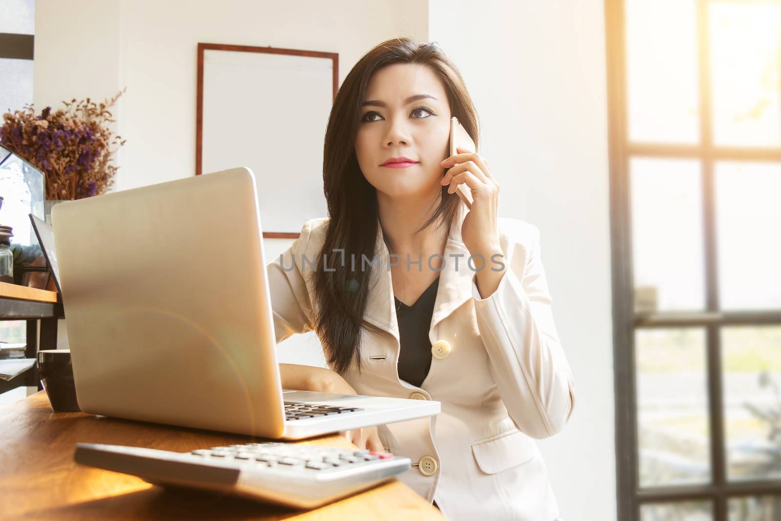 portrait of beautiful and confident Asian business woman in working age using computer laptop technology and smartphone for manage job work. businesswoman ,  girl power and International Women’s Day