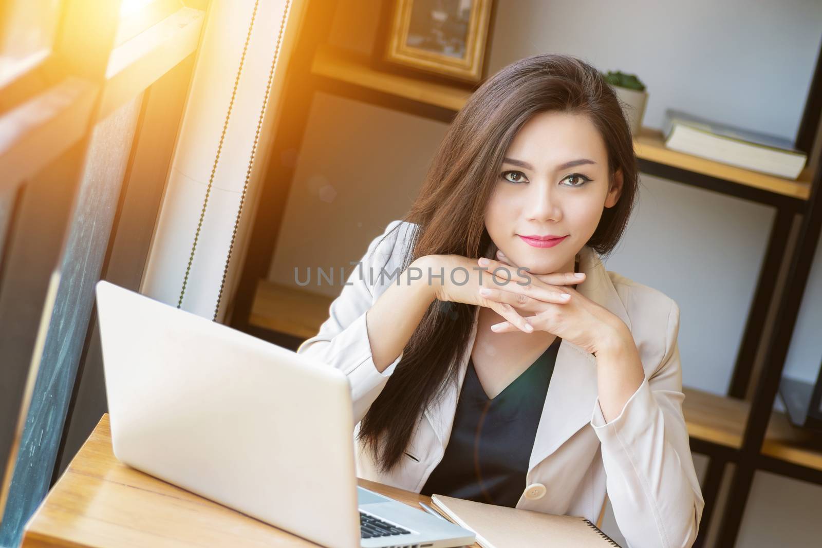 portrait of beautiful and confident Asian business woman in working age using computer laptop technology for manage job work, look at camera. businesswoman ,  girl power and International Women’s Day by asiandelight