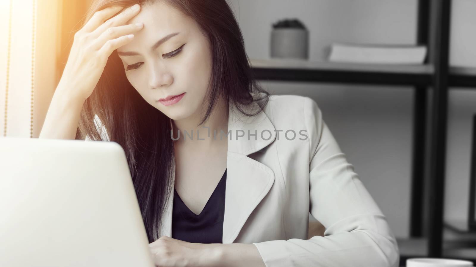 young Asian stress woman at work, depressed woman in the office. portrait of beautiful young Asia female feeling sick, having headache, office syndrome. healthcare at work concept by asiandelight